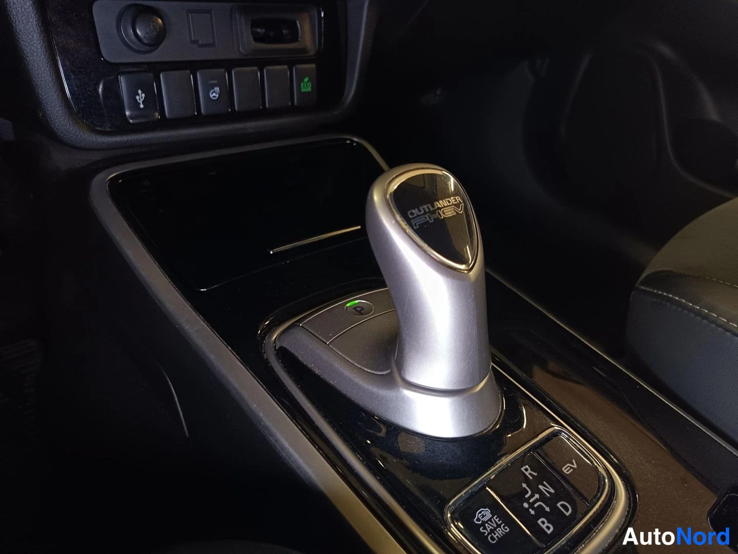 Yksityiskohta: Autowallin avattava lokerikko; sisällä autotaskuja ja paperi.