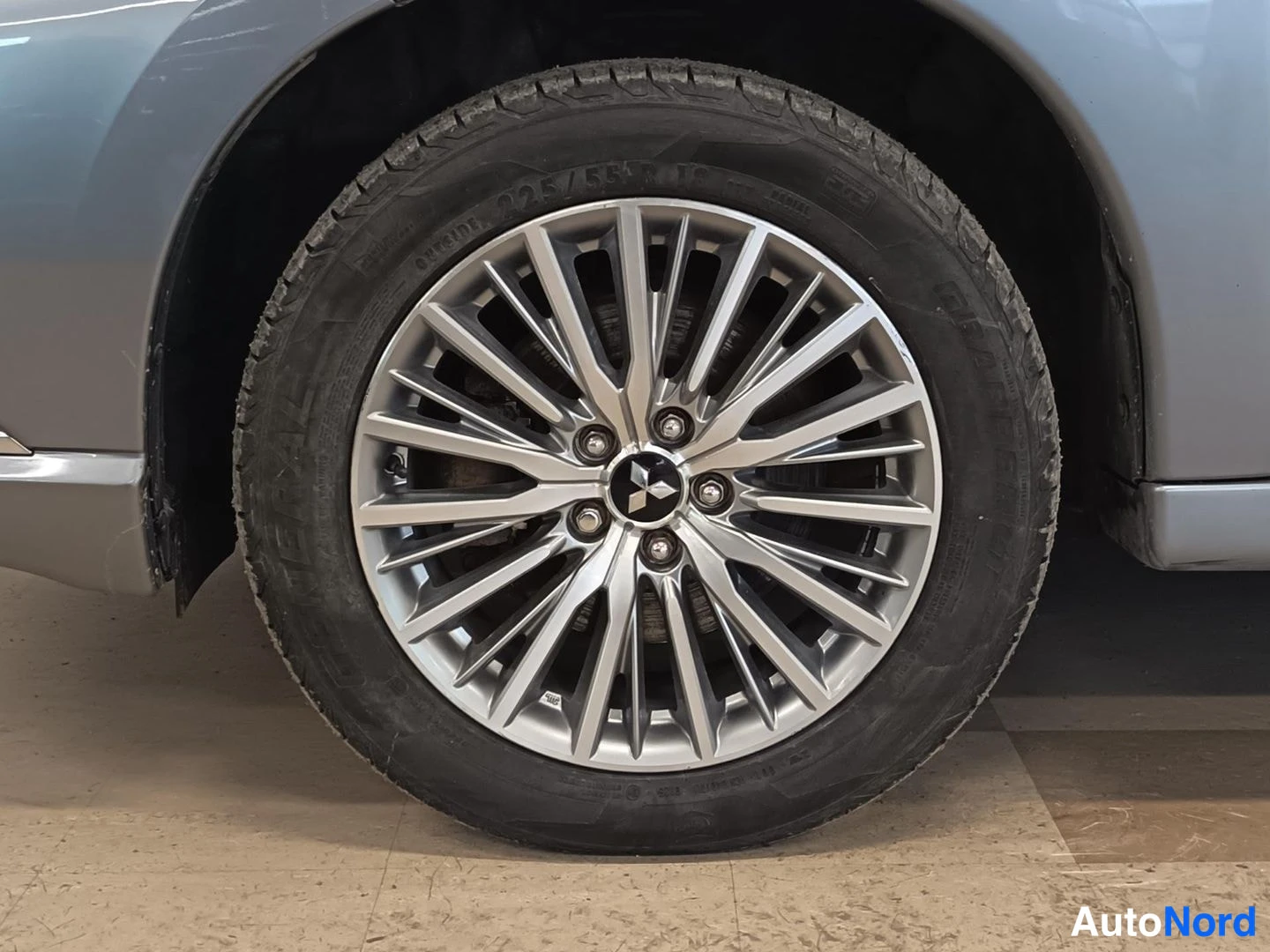 Muu: Hopeinen kevytmetallivanne Mitsubishi-logolla ja rengas, jonka sivussa lukee 225/55 R.