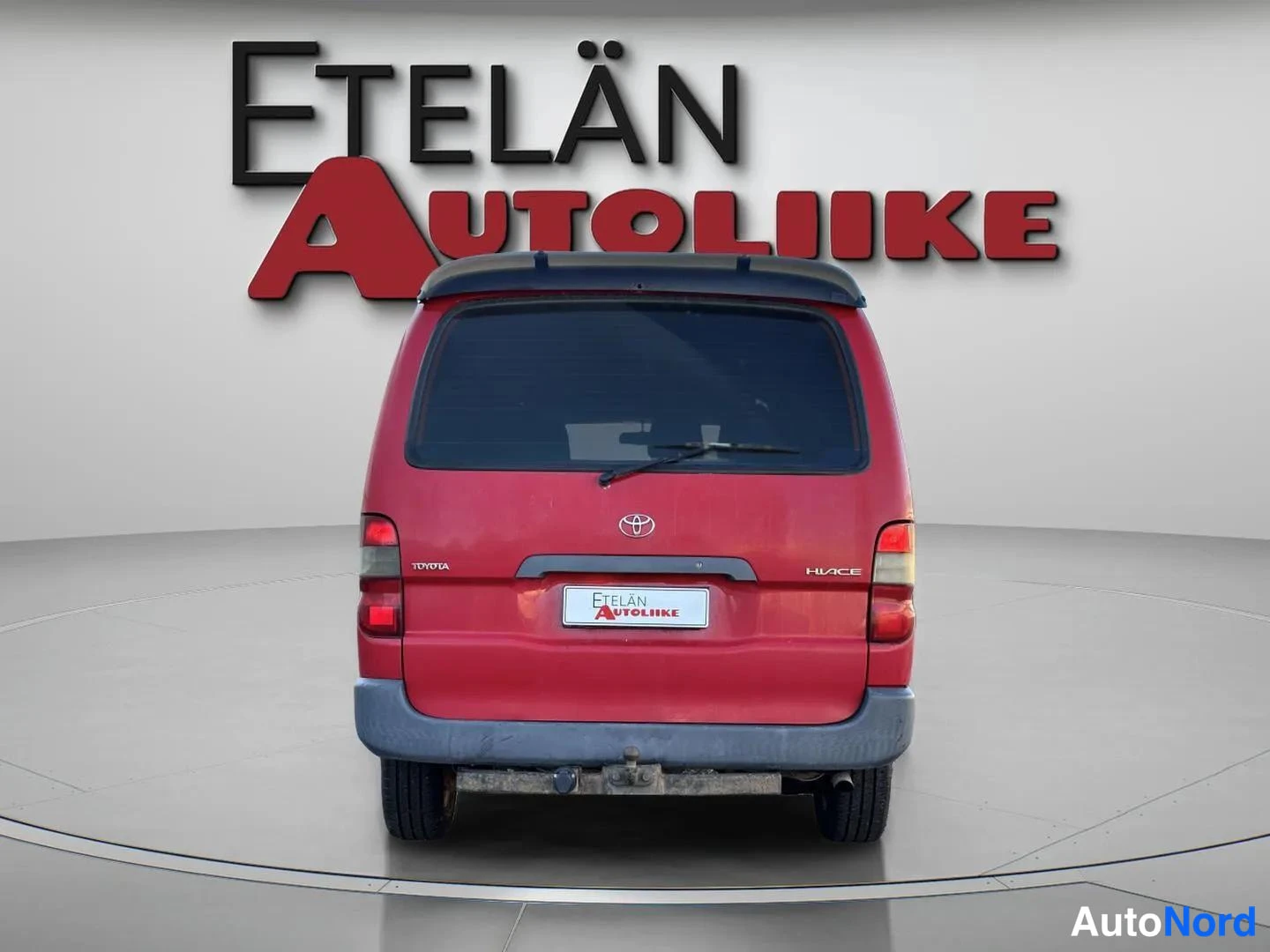 Takaa: Auton takanäkymä, Toyotan logo ja HIACE-merkintä näkyvät takaovessa