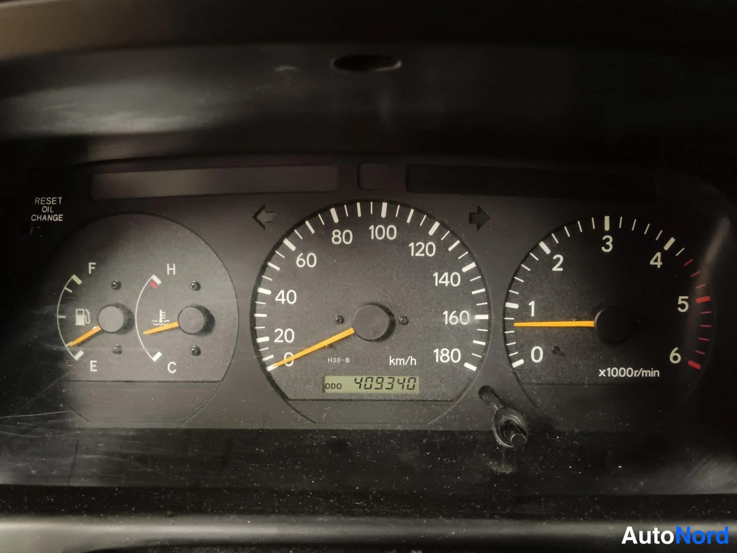 Yksityiskohta: Mittariston lähikuva: nopeusmittari asteikolla 0–180 km/h, kierrosmittari 0–6 x1000r/min, polttoaine- ja lämpömittarit sekä LCD-näytössä odometerilukema 409340.