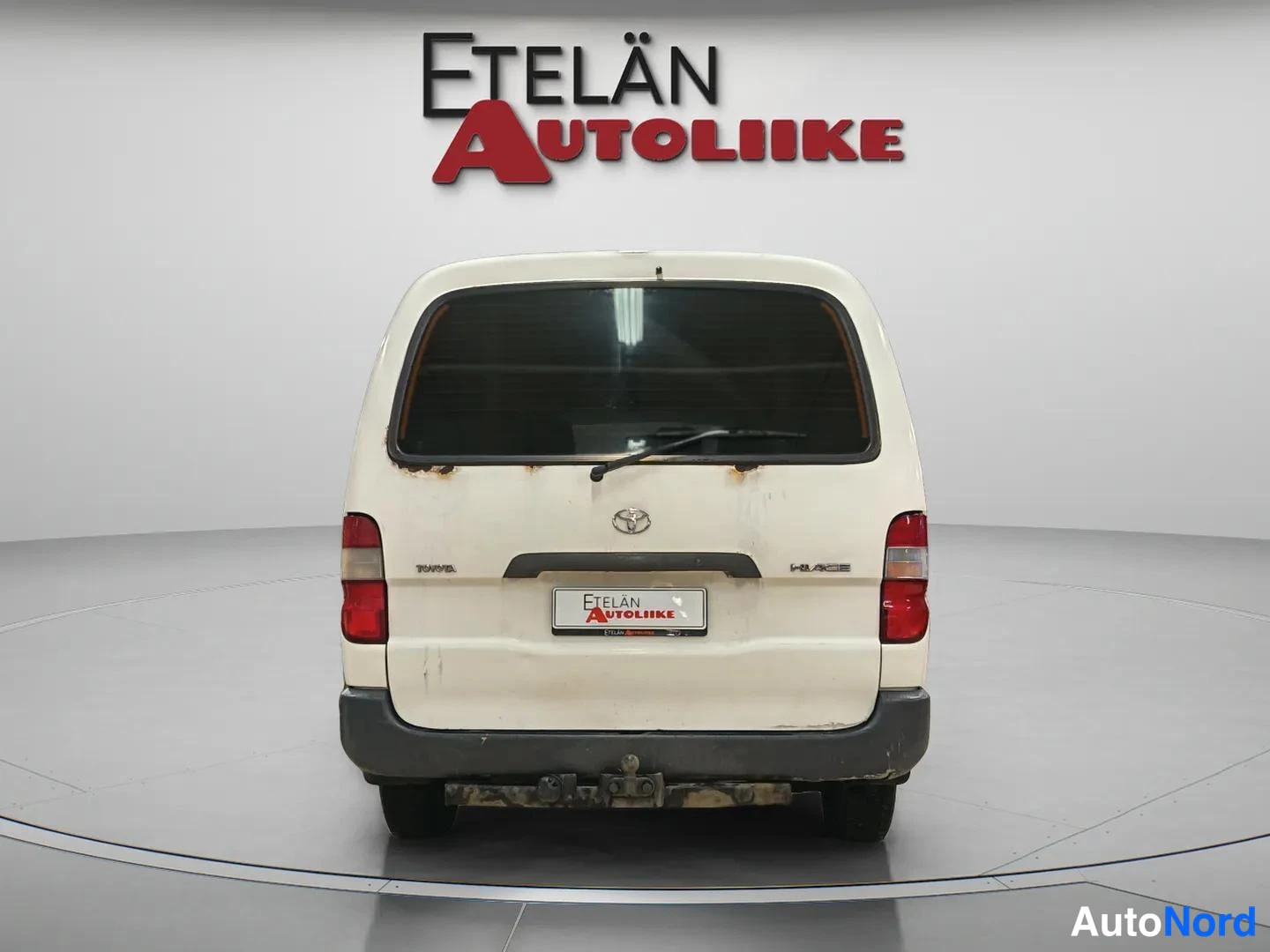 Takaa: Toyota Hiace -pakettiauto suoraan takaa valkoisena studiovalaistuksessa.