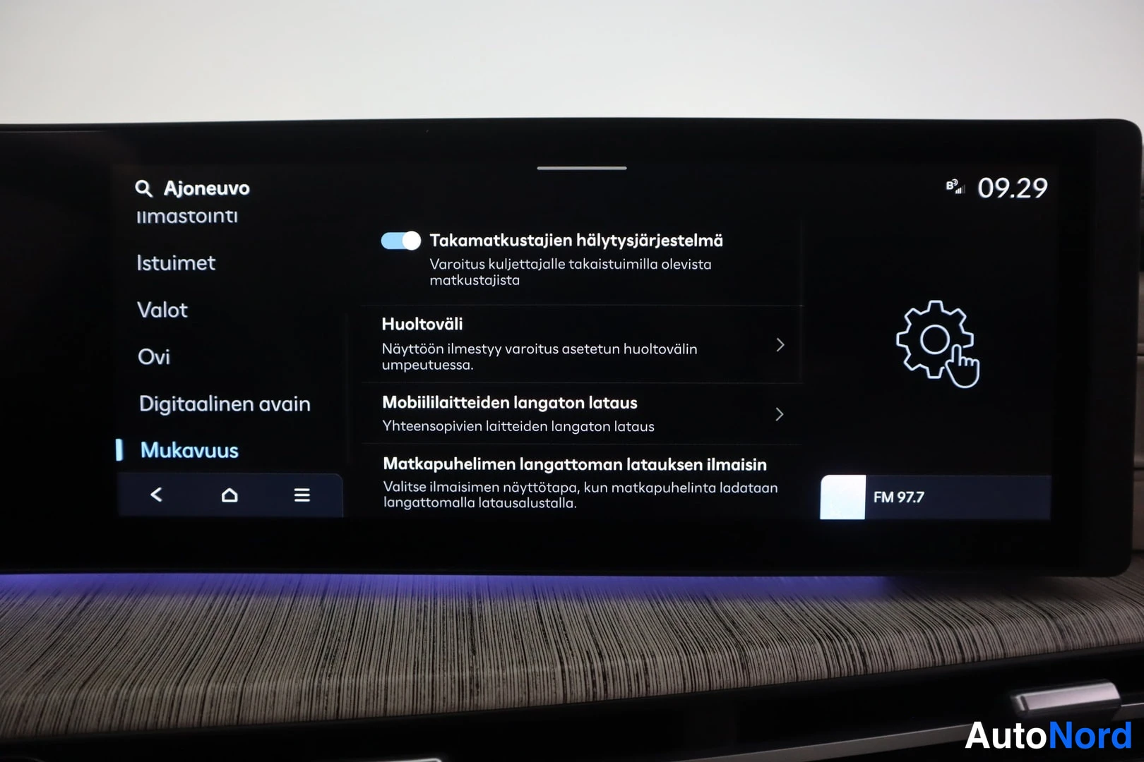 Yksityiskohta: Infotainment-näytön Mukavuus-valikko, jossa takamatkustajien hälytysjärjestelmä, huoltoväli, mobiililaitteiden langaton lataus ja latauksen ilmaisin.