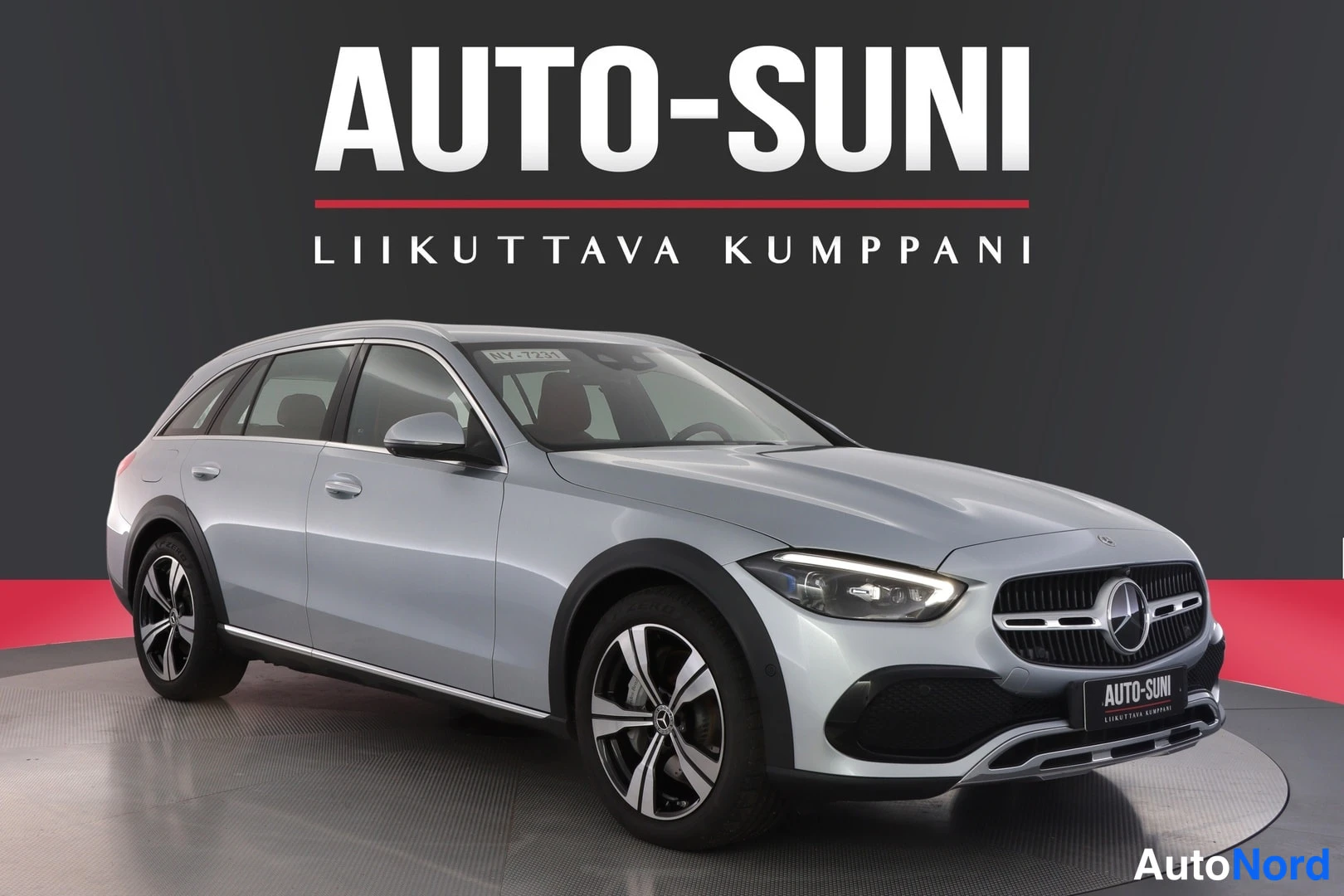Etuviisto, nokka oikealle: Edeltävältä kolmannelta näkökulmalta otettu kuva hopeasta Mercedes-Benz-asennosta. Etusuoja ja keula näkyvät selkeästi, samoin vasen puoli. Auton metal