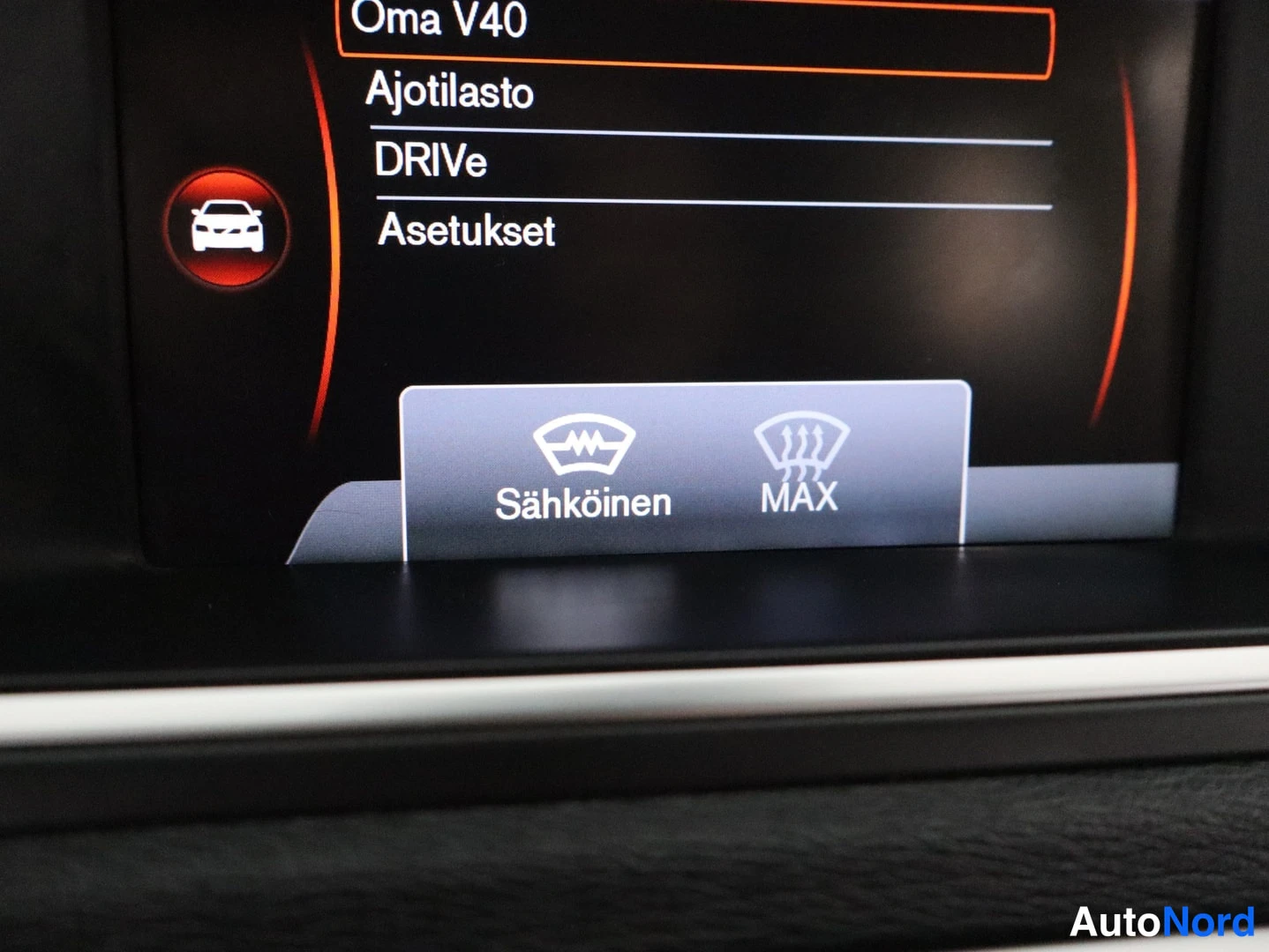 Muu: Infotainment-näytön valikko, jossa vaihtoehdot Oma V40, Ajotilasto, DRIVe ja Asetukset; alaosassa tuulilasinlämmityksen valinnat Sähköinen ja MAX.