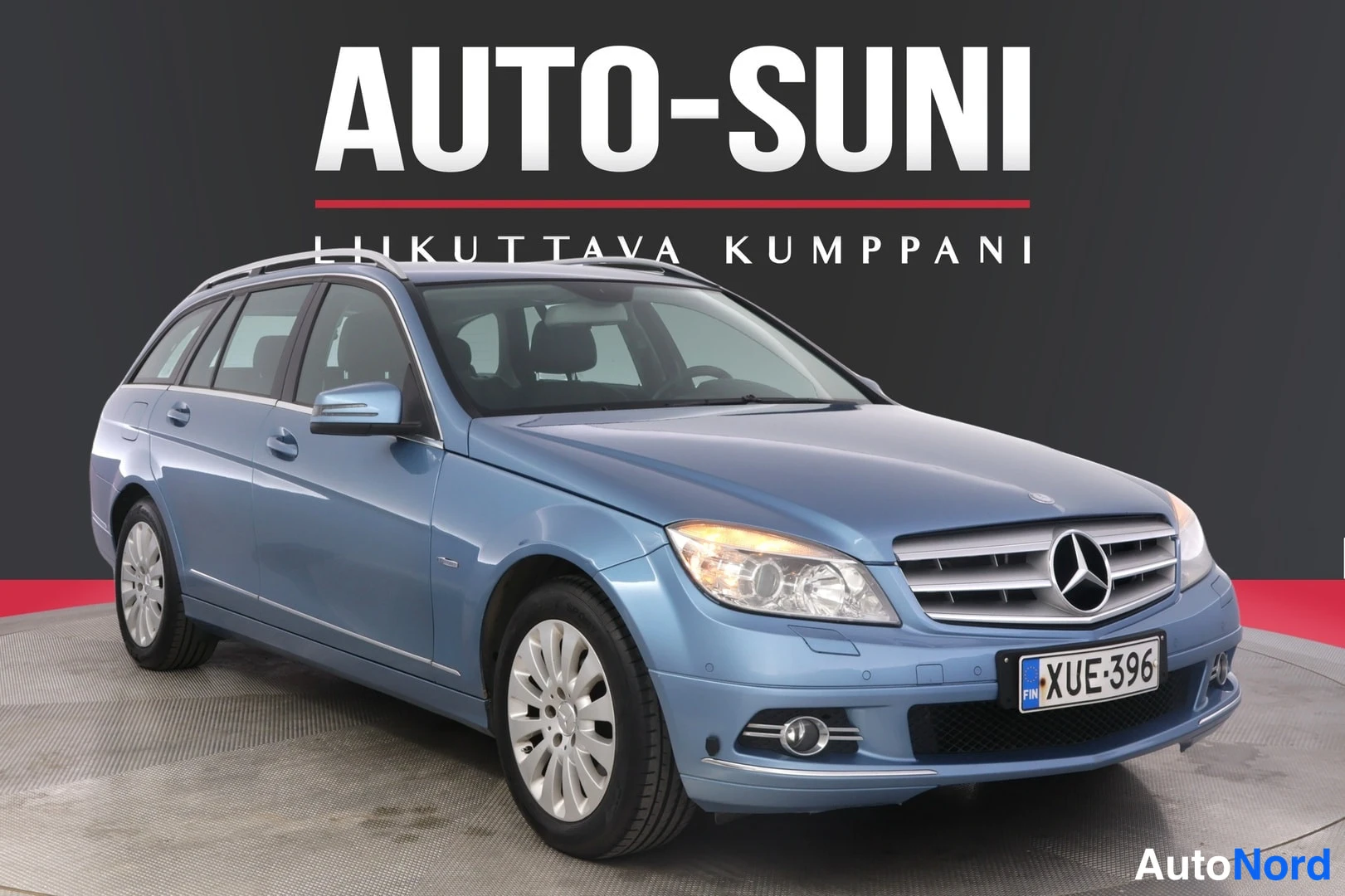 Etuviisto, nokka oikealle: Sininen Mercedes-Benz C-mallin maantiehyppy näkyy etupuolisen neljänneskuvan kulmasta. Etusäleikkö ja merkki keskellä puskuria, valot päällä, etu- ja t