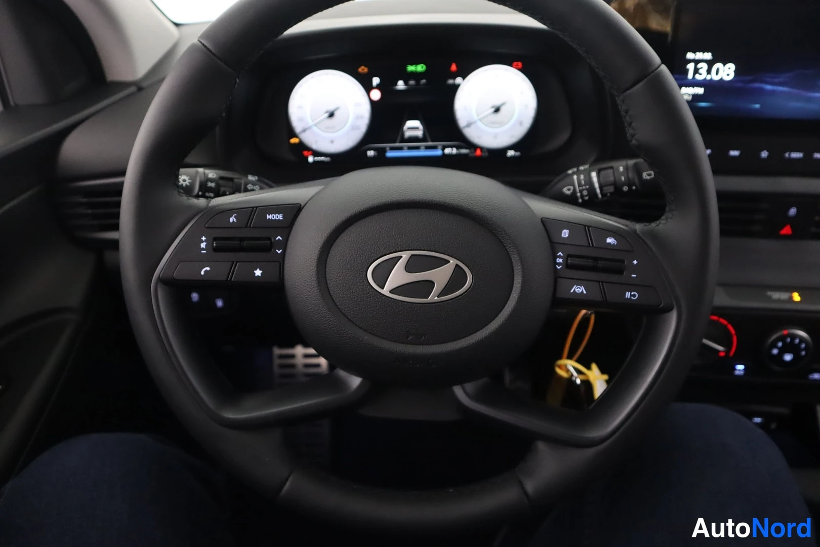 Muu: Close-up of steering wheel with multi-function controls, digital instrument cluster display, and central infotainment screen.