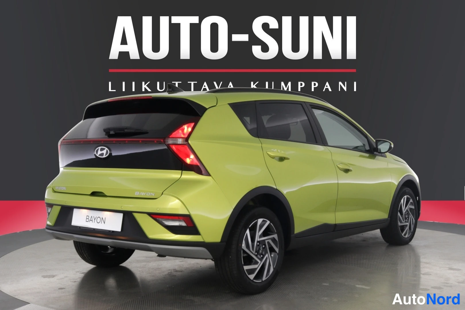Takaviisto: Rear three-quarter view from the right rear side of a lime green car featuring a full-width LED tail light bar connecting the taillights.