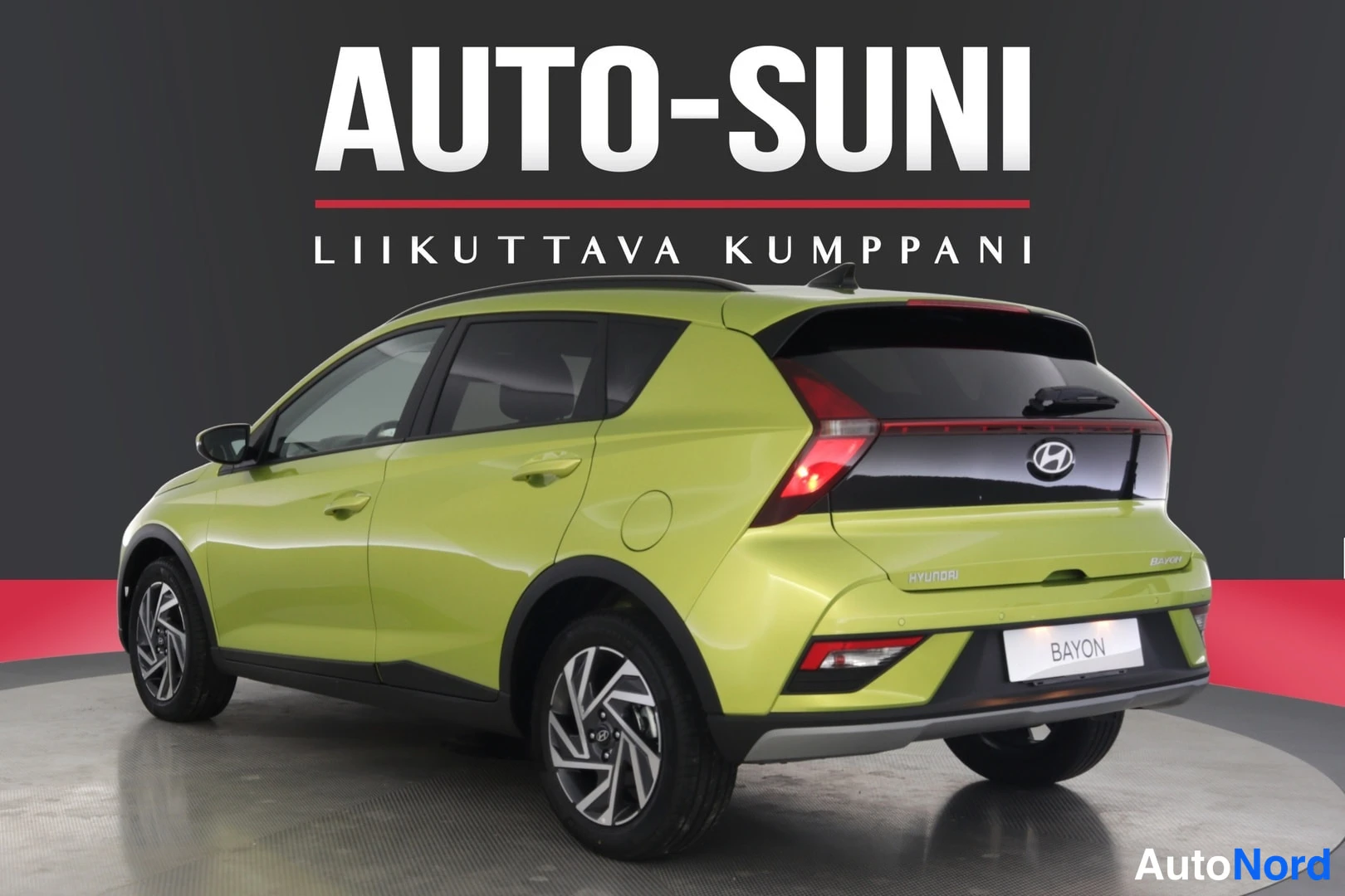 Takaviisto: Rear three-quarter view from the left rear side of a lime green car with roof rails visible above the window line.