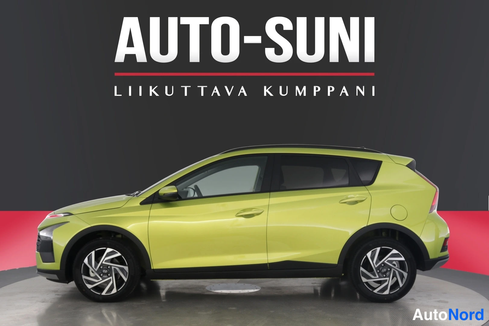 Sivulta: Keltainen auto sivusta. Takavalo, takapuskuri ja takaovien pinnat näkyvät selvästi, etupää ei. Kaksiväriset pyörät.