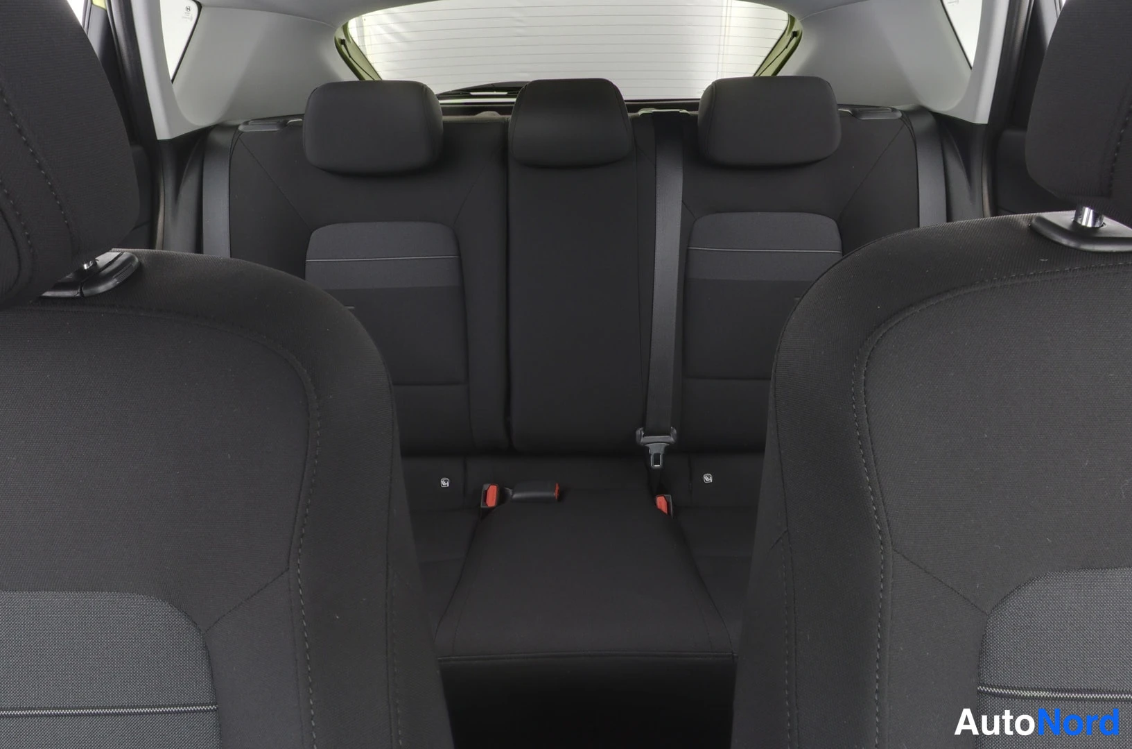 Takaistuimet: Takaisin istuinten läpikatsaus takaa katsottuna. Takasivuhenget, kolme päätyynyä, turvavyöt ja isofix-pisteet näkyvät.