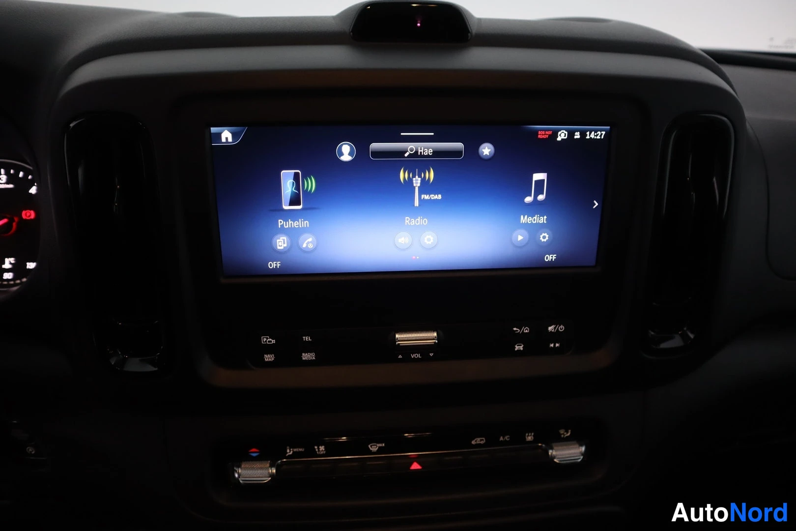 Edestä: Mercedes-Benz Vito:n mittaristön keskinäyttö, jossa valikot Puhelin, Radio FM/DAB ja Mediat; alla TEL- ja VOL-napit sekä ilmastointipaneeli A/C-merkinnällä.