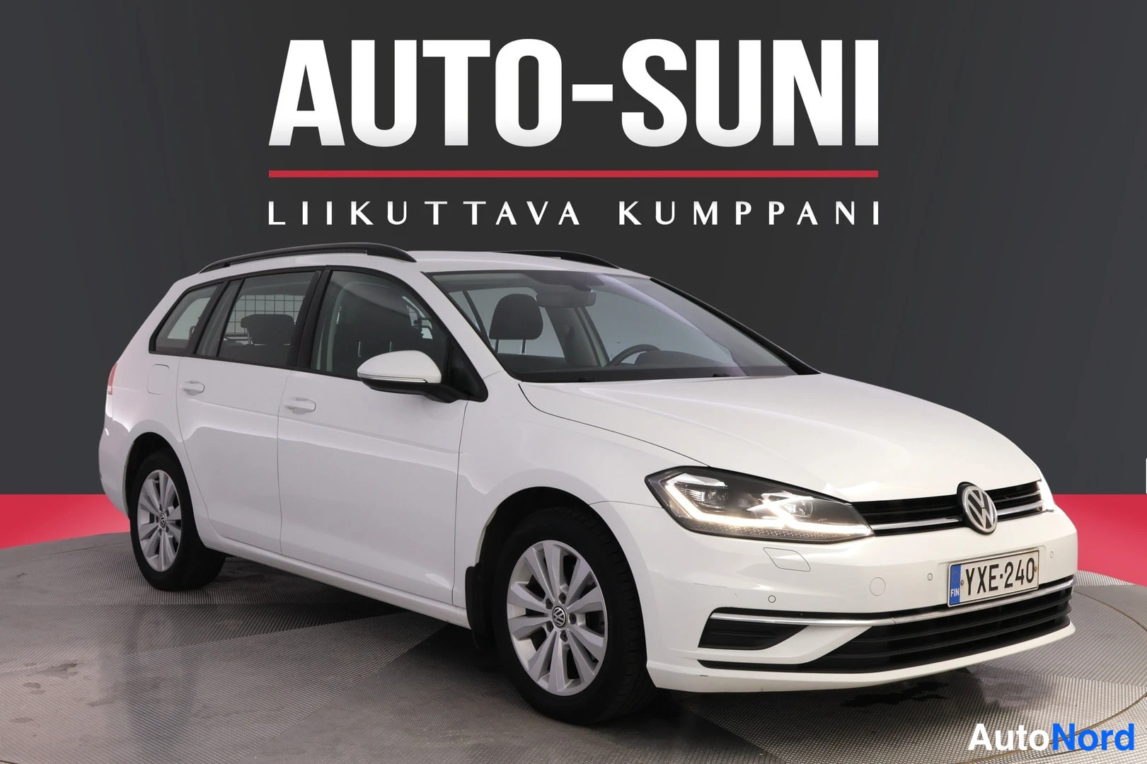 Etuviisto, nokka oikealle: White Volkswagen Golf station wagon photographed from the front three-quarter angle on a grey background with 'AUTO-SUNI' text overlay. Front grille, h