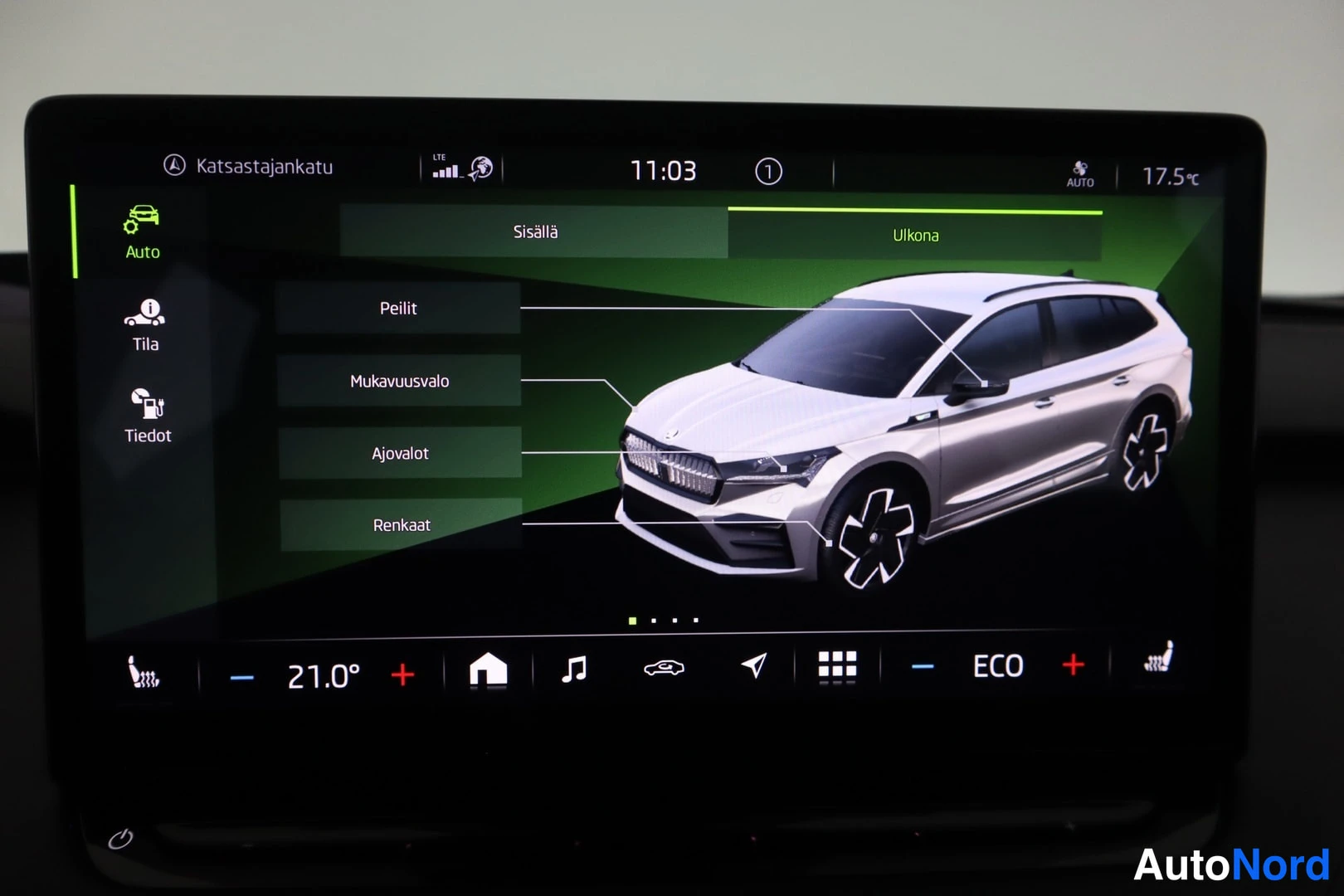 Yksityiskohta: Infotainment-näytön Auto-valikko, Ulkona-välilehti valittuna: Peilit, Mukavuusvalo, Ajovalot ja Renkaat -asetukset autonkuvan vieressä.