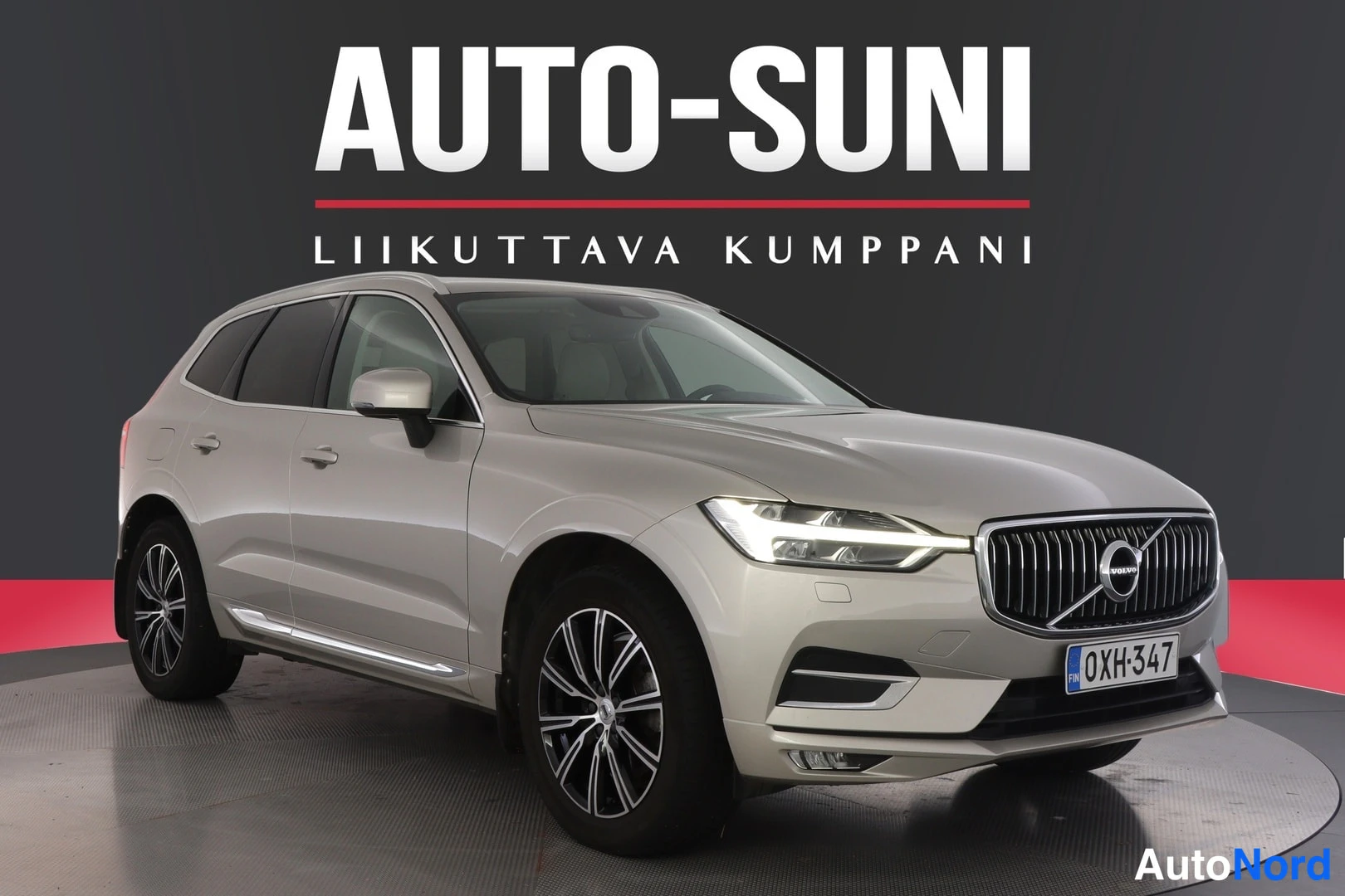 Etuviisto, nokka oikealle: Vaaleanbeige farmarityyppinen Volvo XC60 etuviistosta oikealta studio-ottelussa, rekisterikilpi.