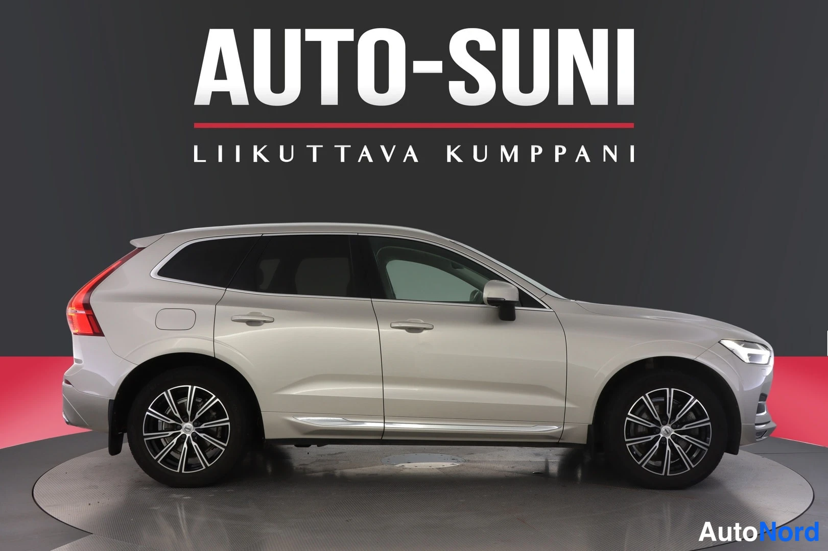 Etuviisto, nokka oikealle: Beige Volvo XC60 -maasturin etukulman sivukuva studiotaustaa vasten, etusäleikkö kuvan oikeassa reunassa.