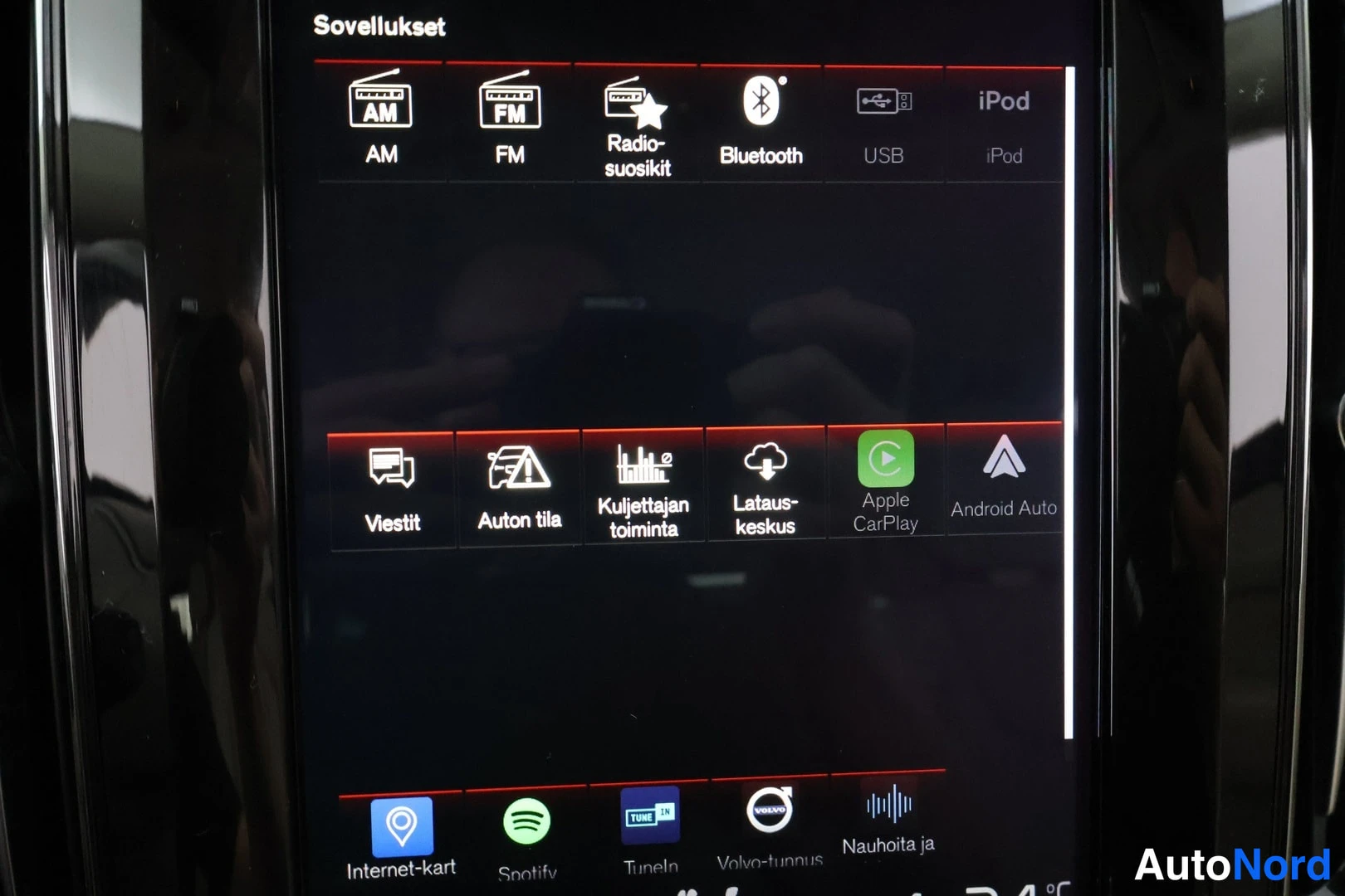 Muu: Auton infotainment-näytön lähikuva: Sovellukset-valikko, jossa kuvakkeet mm. Apple CarPlay, Android Auto, Bluetooth ja USB.