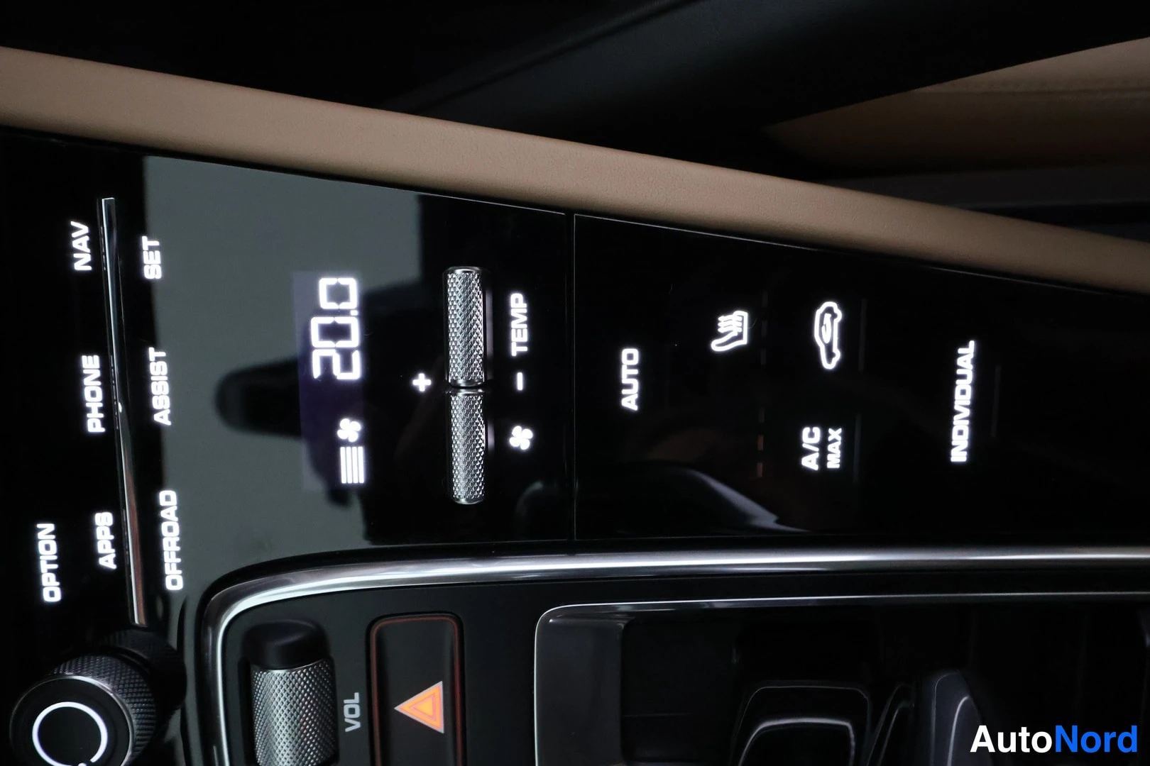 Muu: Auton keskikonsolin valaistu hallintapaneeli: lämpötila 20,0, painikkeet NAV, PHONE, OPTION, APPS, ASSIST, OFFROAD, TEMP, AUTO, A/C MAX ja INDIVIDUAL.