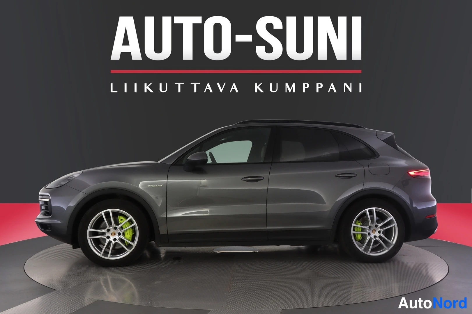 Sivulta: Tummanharmaa Porsche Cayenne -maasturin sivuprofiili studio­taustaa vasten, vasen kylki näkyvissä.
