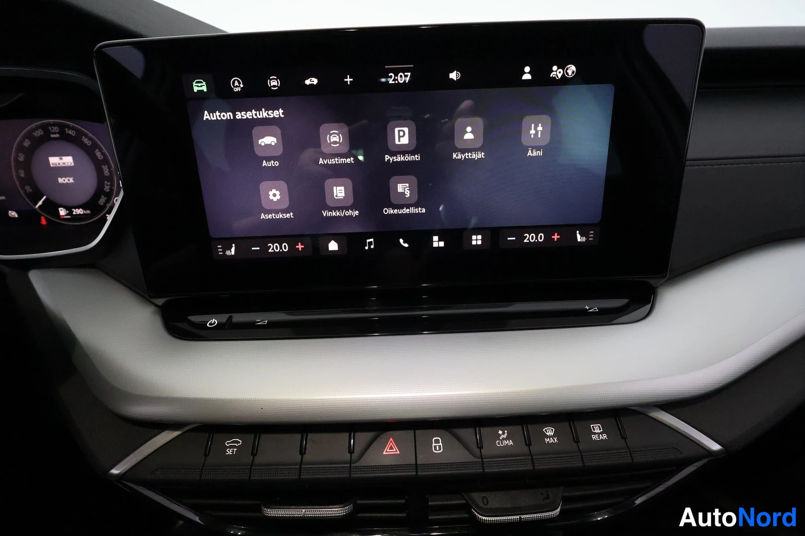 Muu: Kojelaudan infotainment-näyttö, jossa avoinna 'Auton asetukset' -valikko kuvakkeineen kuten Auto, Avustimet, Pysäköinti ja Ääni; lämpötila näytetään 20 astetta.