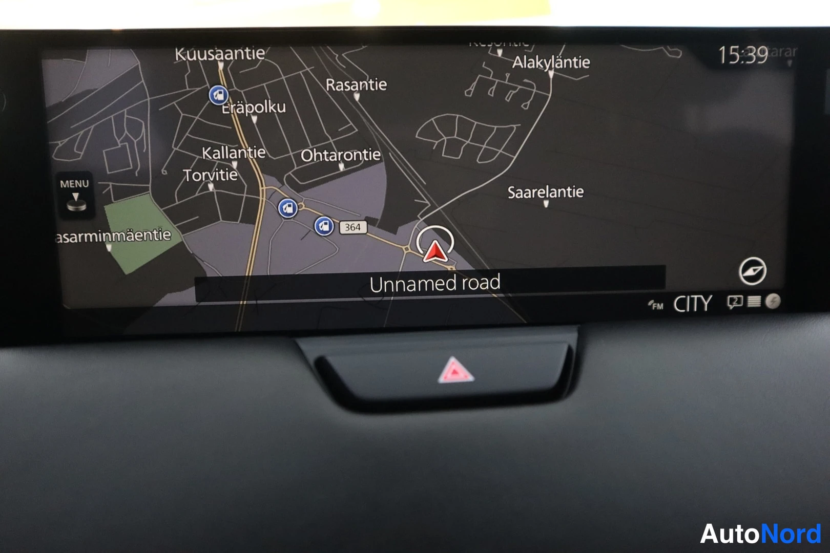 Yksityiskohta: Auton keskinäytössä näkyy navigaatio­kartta alueella Kuusaantie ja Ohtarontie, teksti 'Unnamed road'.