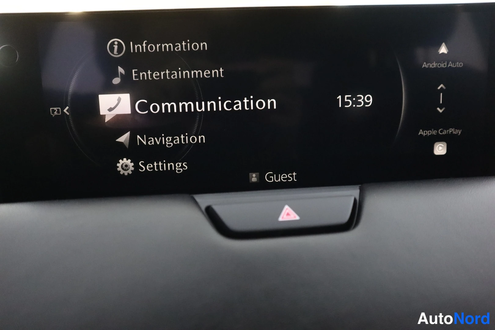 Yksityiskohta: Auton näytön päävalikko vaihtoehtoina Information, Entertainment, Communication, Navigation ja Settings; Android Auto ja Apple CarPlay -kuvakkeet oikealla.