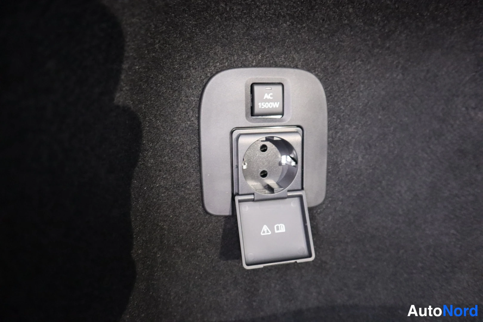 Yksityiskohta: Schuko-pistorasia AC 1500W -kytkimellä tummassa sisäpanelissa.