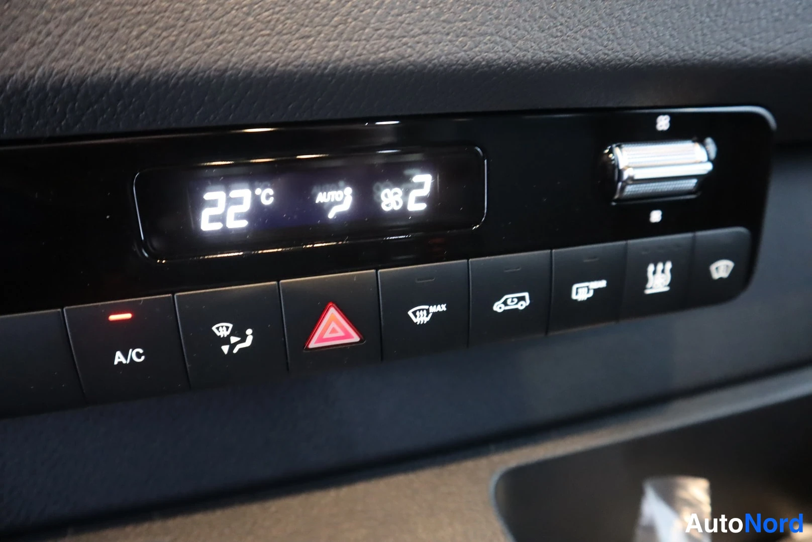 Muu: Ilmastoinnin ohjauspaneeli: näyttö 22 °C, AUTO ja puhallustaso 2, A/C- ja maksiminauhoitus- ym. painikkeet.