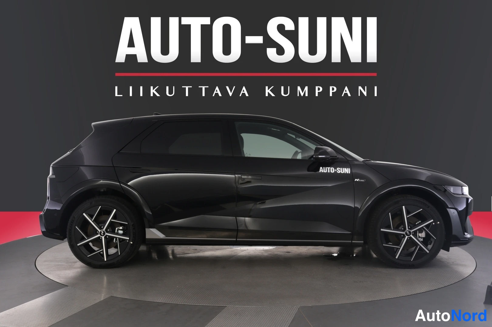 Etuviisto: Musta Hyundai Ioniq 5 -henkilöauto studio-valkopohjaisessa kuvassa kolmivaiheisessa etunäkymässä, rekisterikilpi näkyvissä.