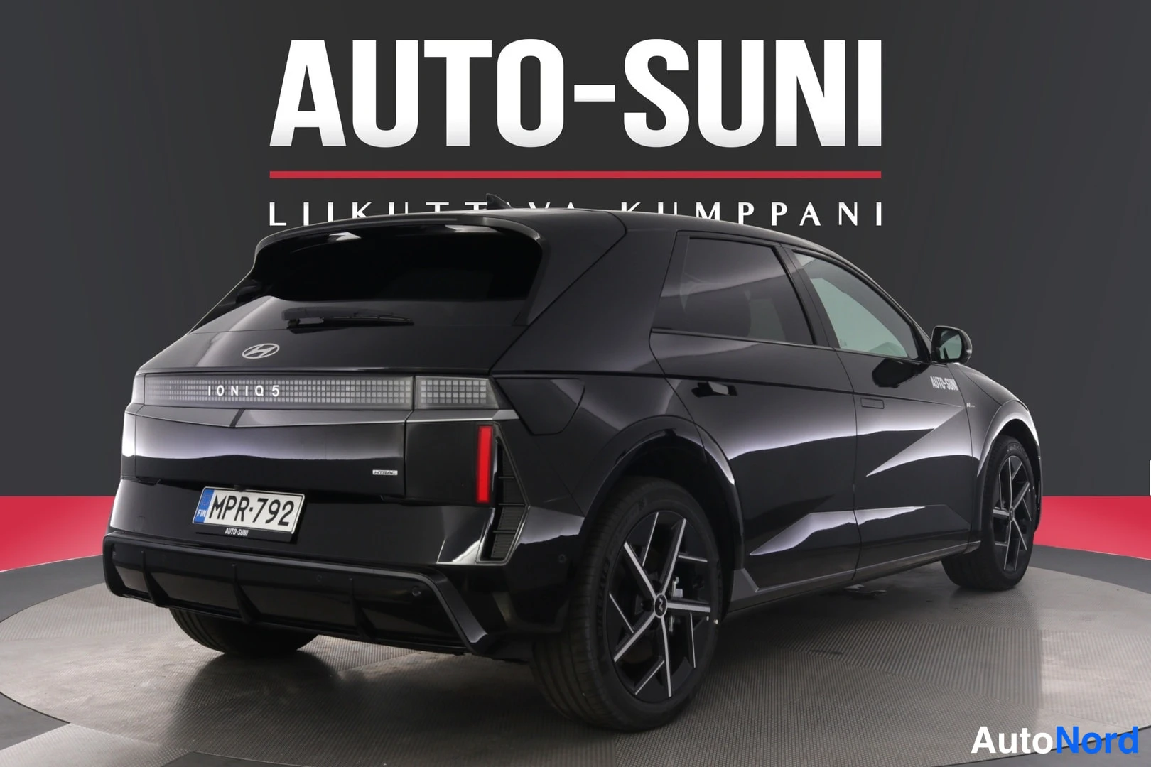 Etuviisto: Musta Hyundai Ioniq 5 -henkilöauto studio-valkopohjaisessa kuvassa kolmivaiheisessa etunäkymässä, rekisterikilpi näkyvissä.