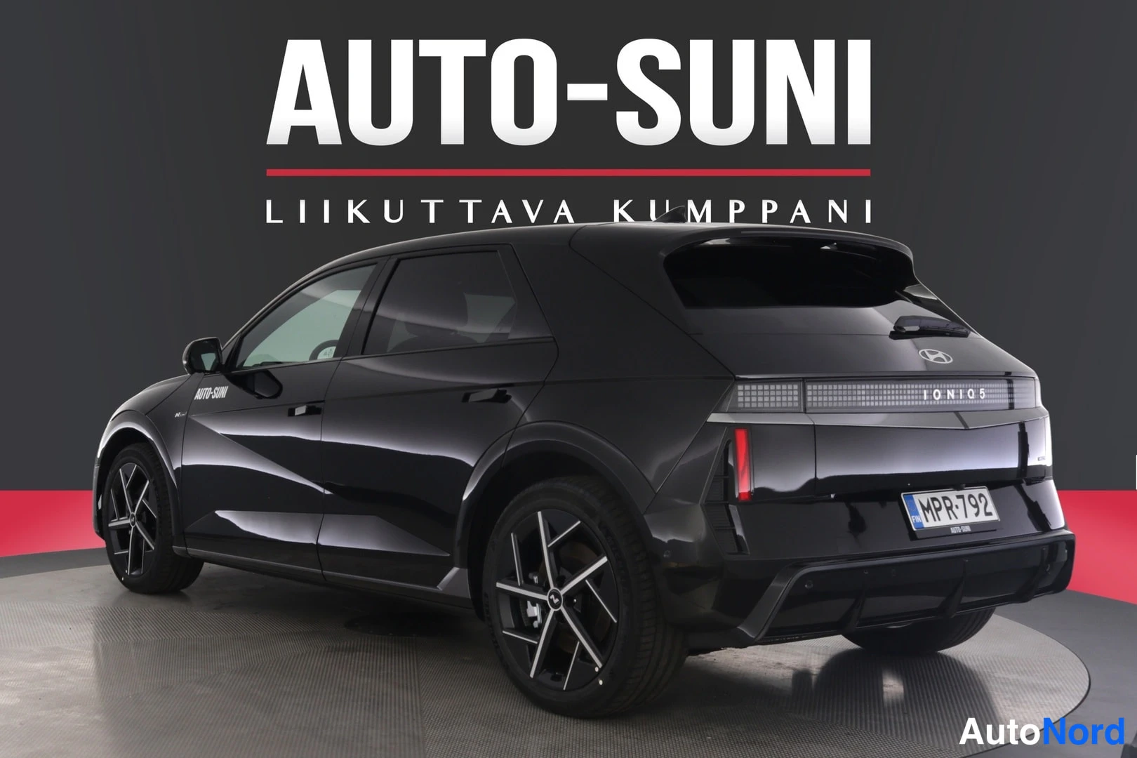Etuviisto: Musta Hyundai Ioniq 5 -henkilöauto studio-valkopohjaisessa kuvassa kolmivaiheisessa etunäkymässä, rekisterikilpi näkyvissä.