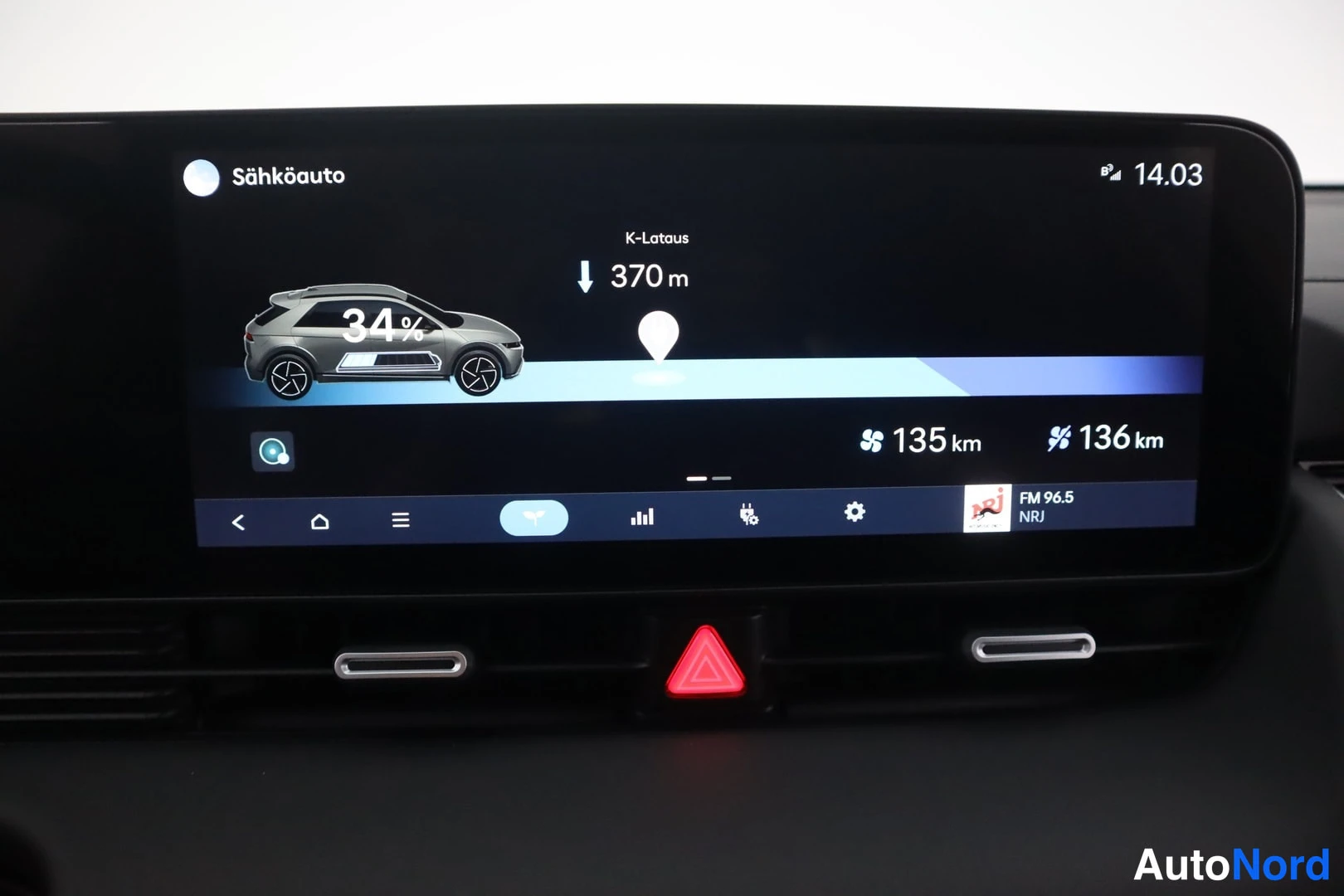 Muu: Hyundai IONIQ 5:n infotainment-näyttö latausnäkymässä: akku 34 %, K-lataus 370 m, kantama 135 km ja 136 km.