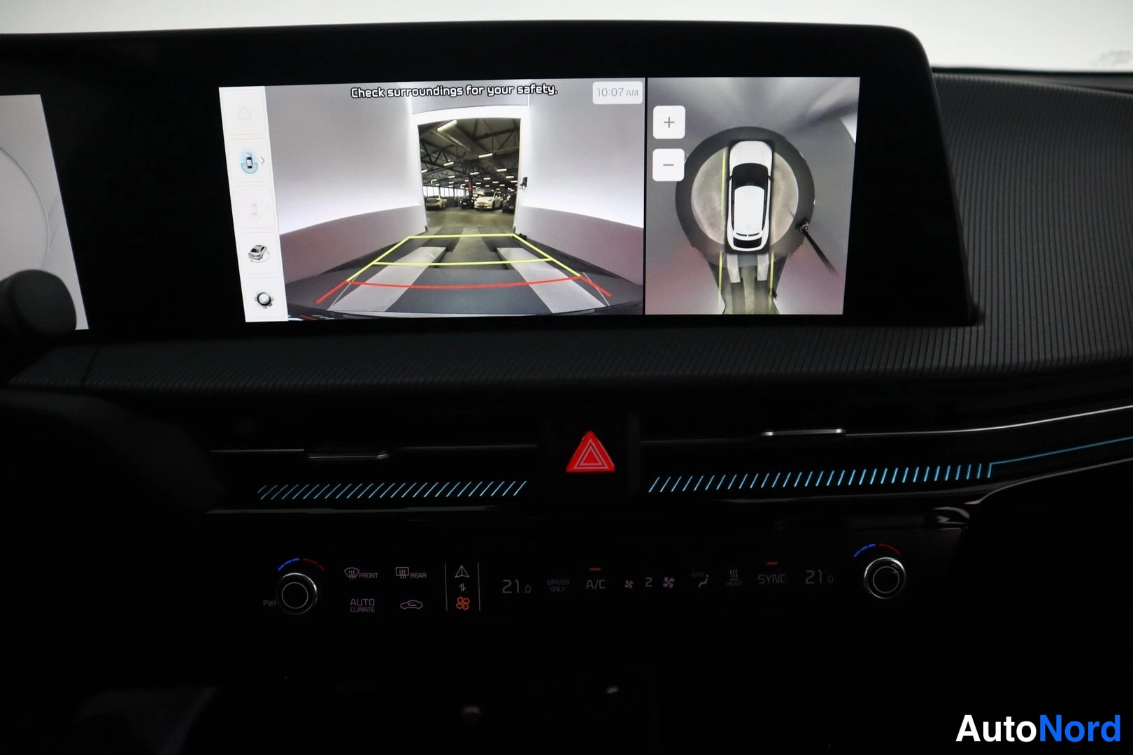Muu: Keskiritan infotainment-näyttö näyttää 360-kaartukuvan ja peruutuskameran kuvan; alla ilmastointipaneeli (21°C, A/C, SYNC).