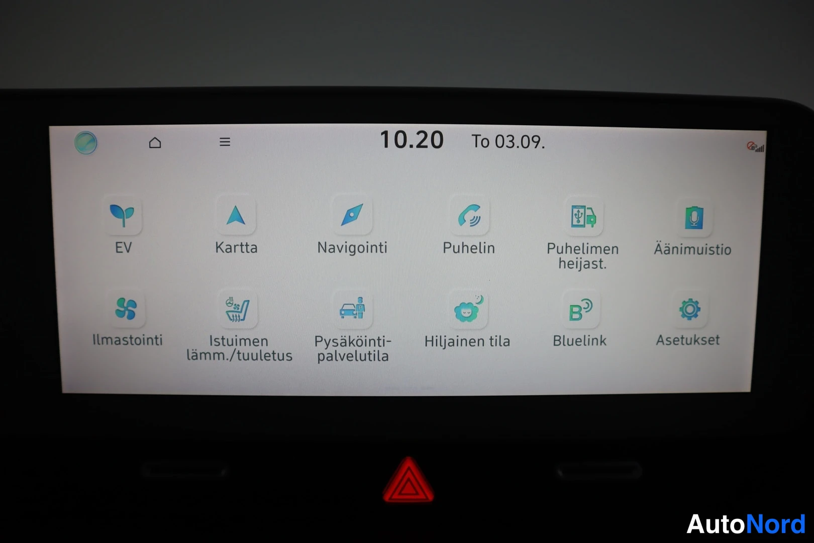 Yksityiskohta: Infotainment-näytön valikko kuvakkeilla EV, Kartta, Navigointi, Puhelin, Puhelimen heijastus, Äänimuistio, Ilmastointi, Istuimen lämm./tuuletus, Pysäköinti-palv