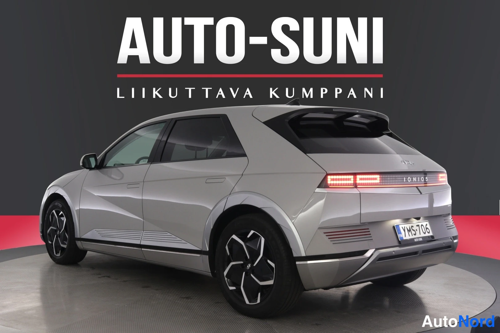 Takaviisto: Autosuni-logo tummalla taustalla; hopeanharmaan Hyundai IONIQ 5:n takakulmanäkymä kulmikkailla pixel-takavaloilla, rekisterikilpi.