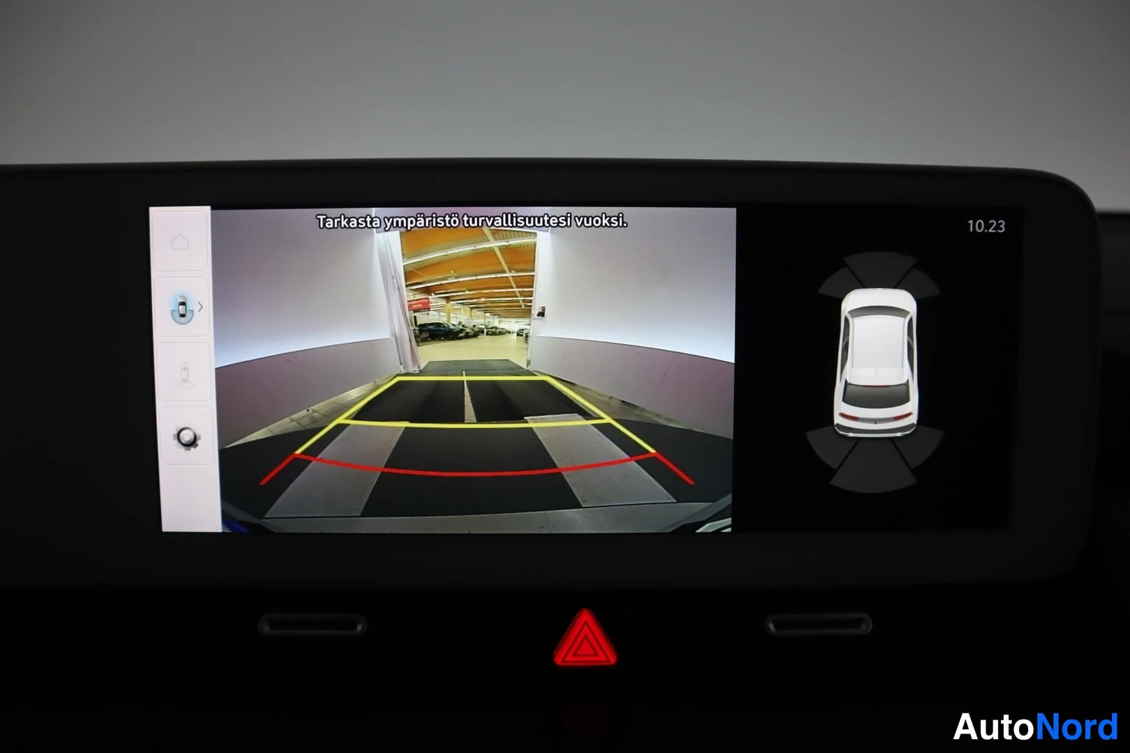 Muu: Infotainment-näytöllä peruutuskameran kuva parkkihallista ja ympäröivän näkymän kaavio