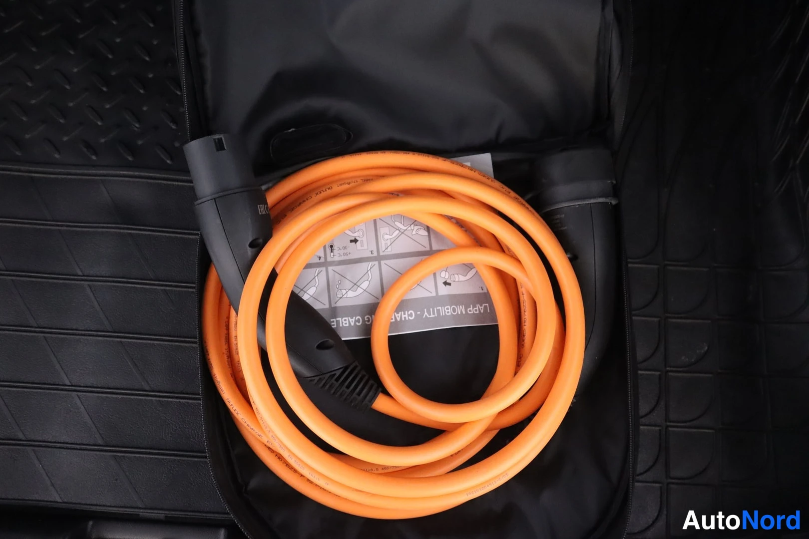 Muu: Oranssi Lapp Mobility -latauskaapeli rullalla autotarvikelaukussa.