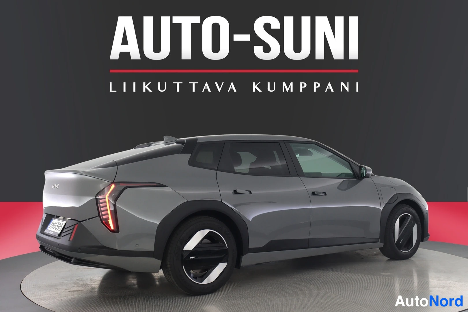 Takaviisto: Kia EV4, takaosa kolmesta neljäsosasta näkyvissä, harmaa koripaneeli, takavalo- ja rekisterikilven alue näkyvissä