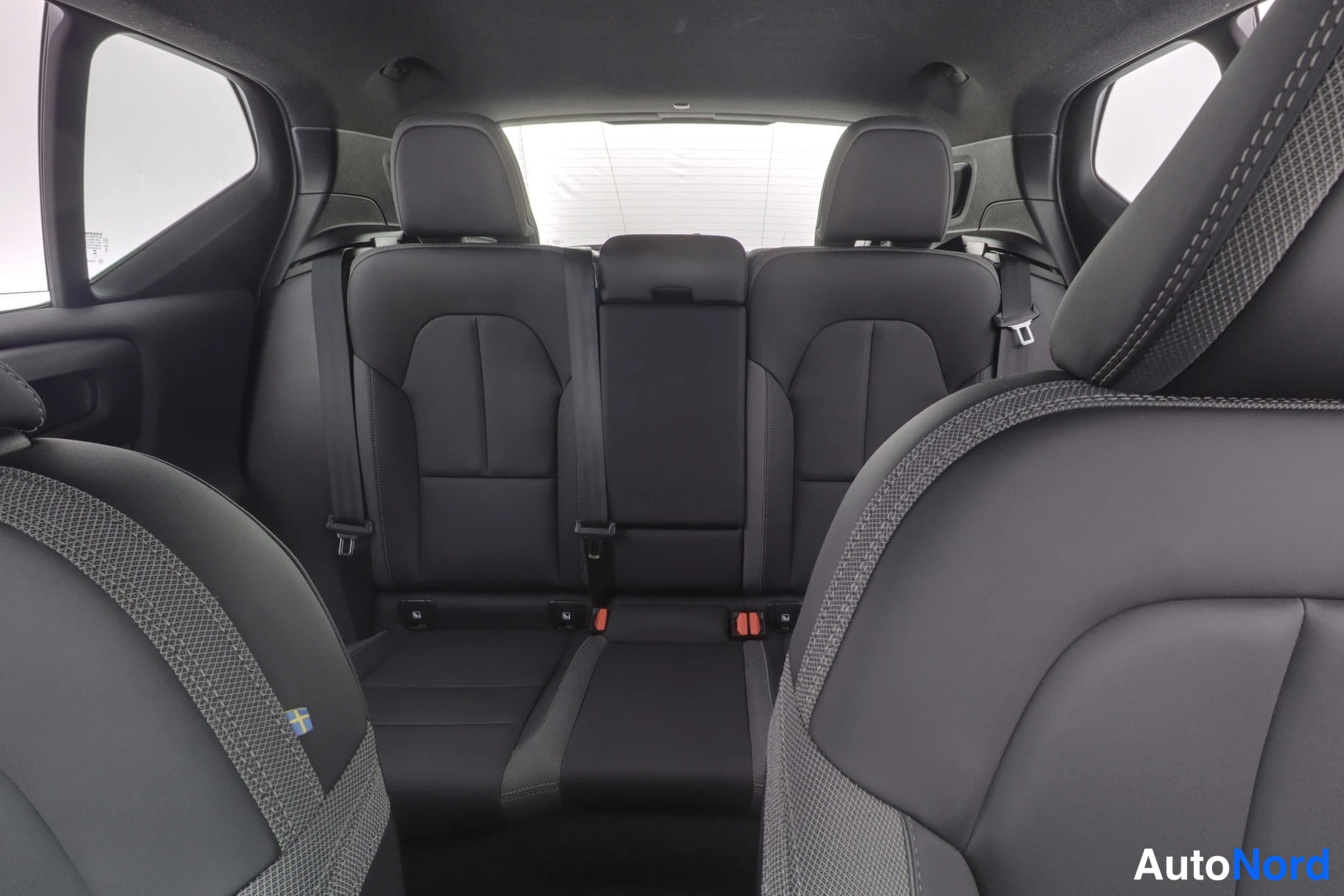 Edestä: Volvo XC40:n takapenkkien istuimet tummilla kankailla, katsotaan etupenkkien yli.
