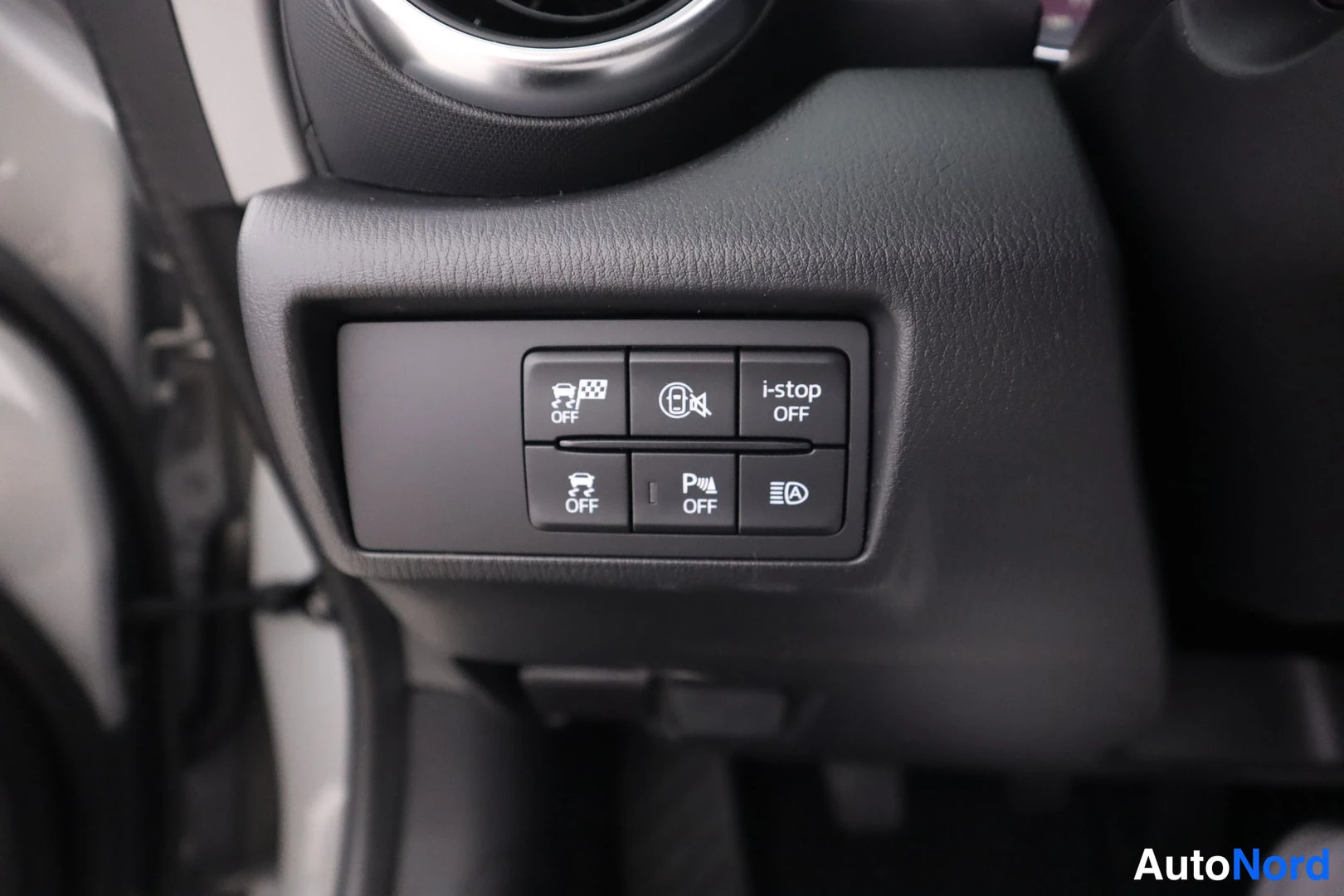 Yksityiskohta: Autojen sisällä: kytkinpaneeli OFF- ja i-stop-tekstillä