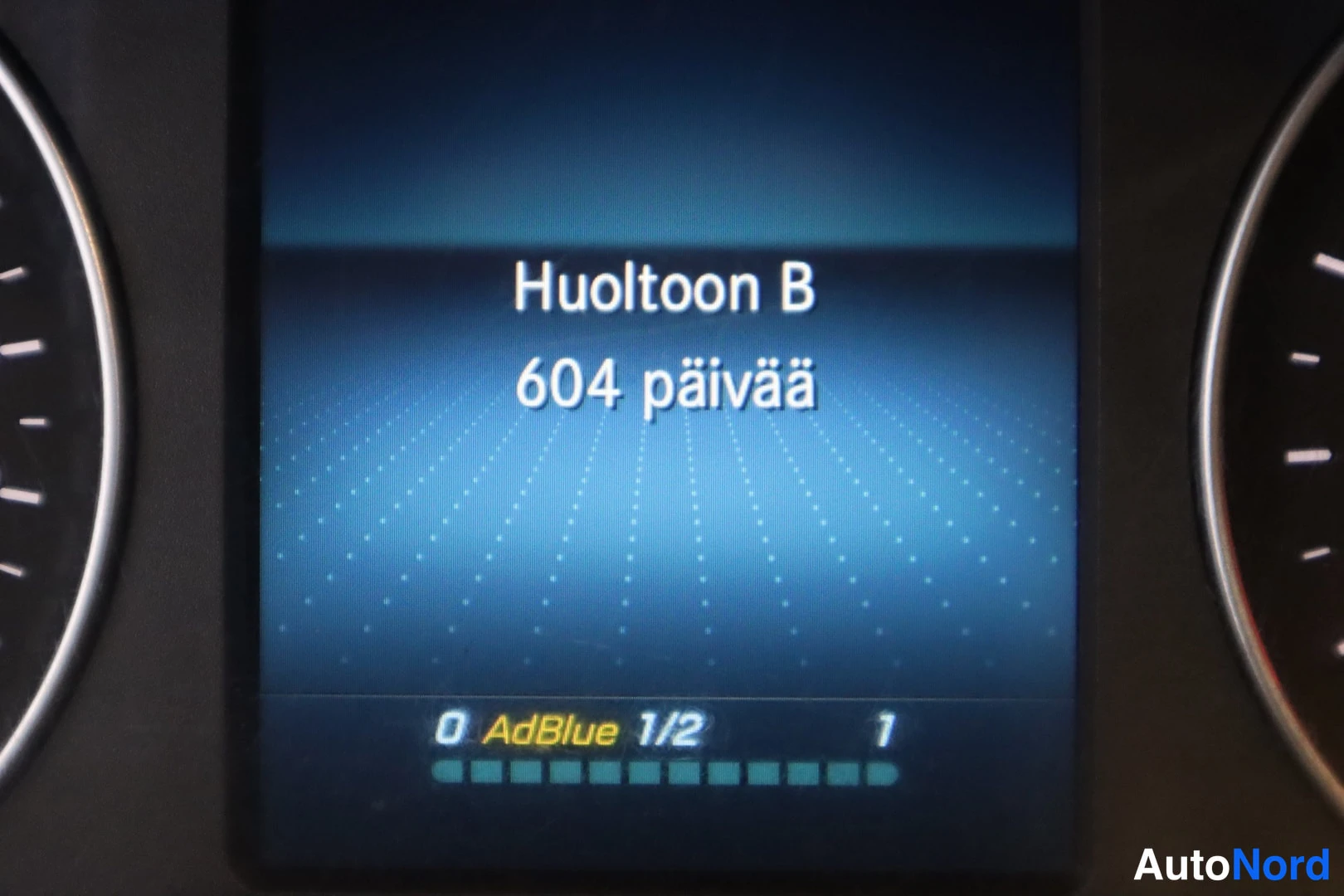 Yksityiskohta: Mercedes-Benz Sprinter 2019: Mercedes-Benz Sprinter 2019: Huolto B-palkkien paneeli tekstillд 'Huoltoon B 604 pдivдд' ja 'AdBlue'.
