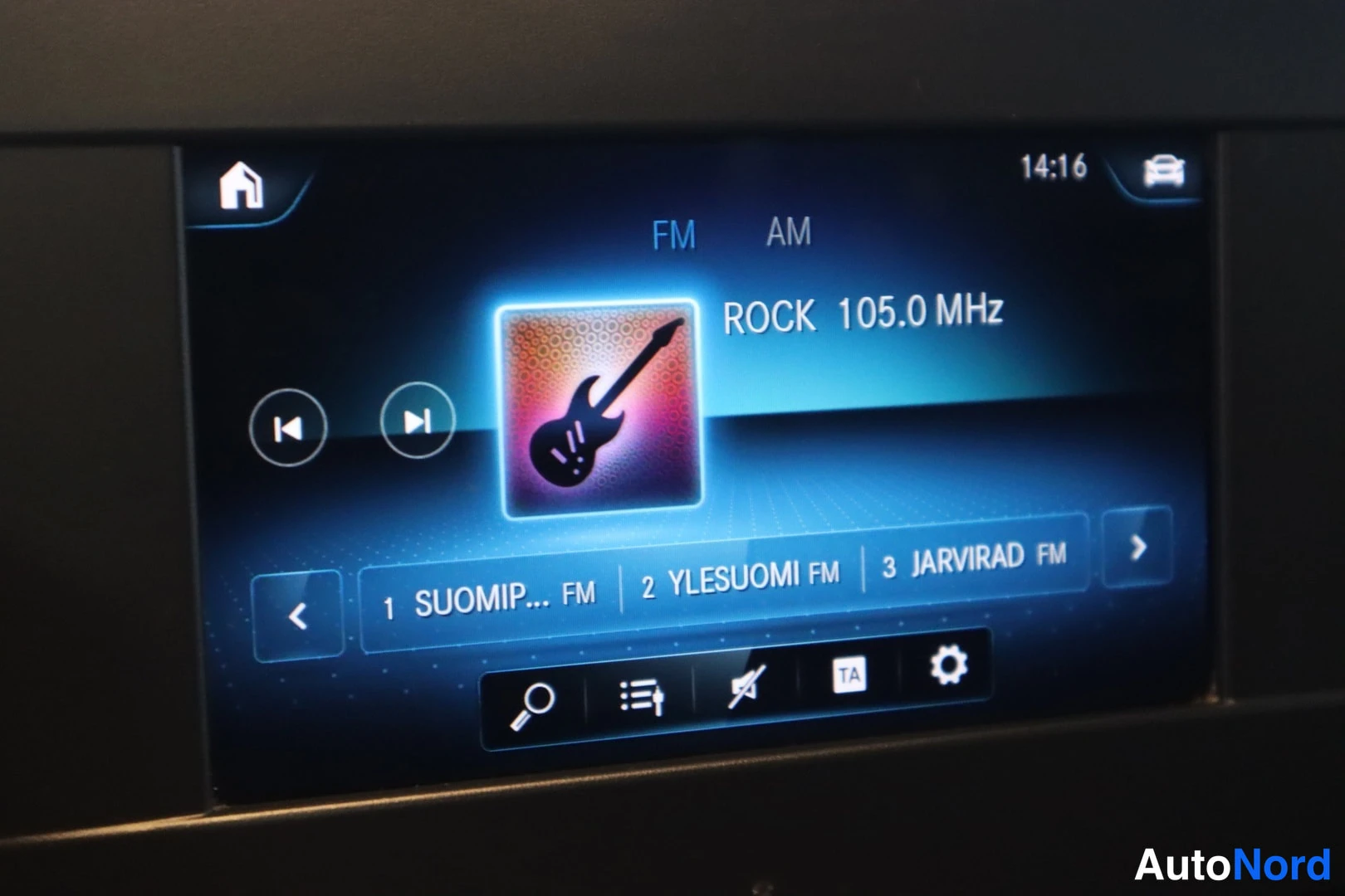 Yksityiskohta: Infotainment-näytön radiovalikko FM-aalloilla, valittuna kanava 'ROCK 105.0 MHz', kanavalista SUOMIP…, YLESUOMI FM ja JARVIRAD FM.
