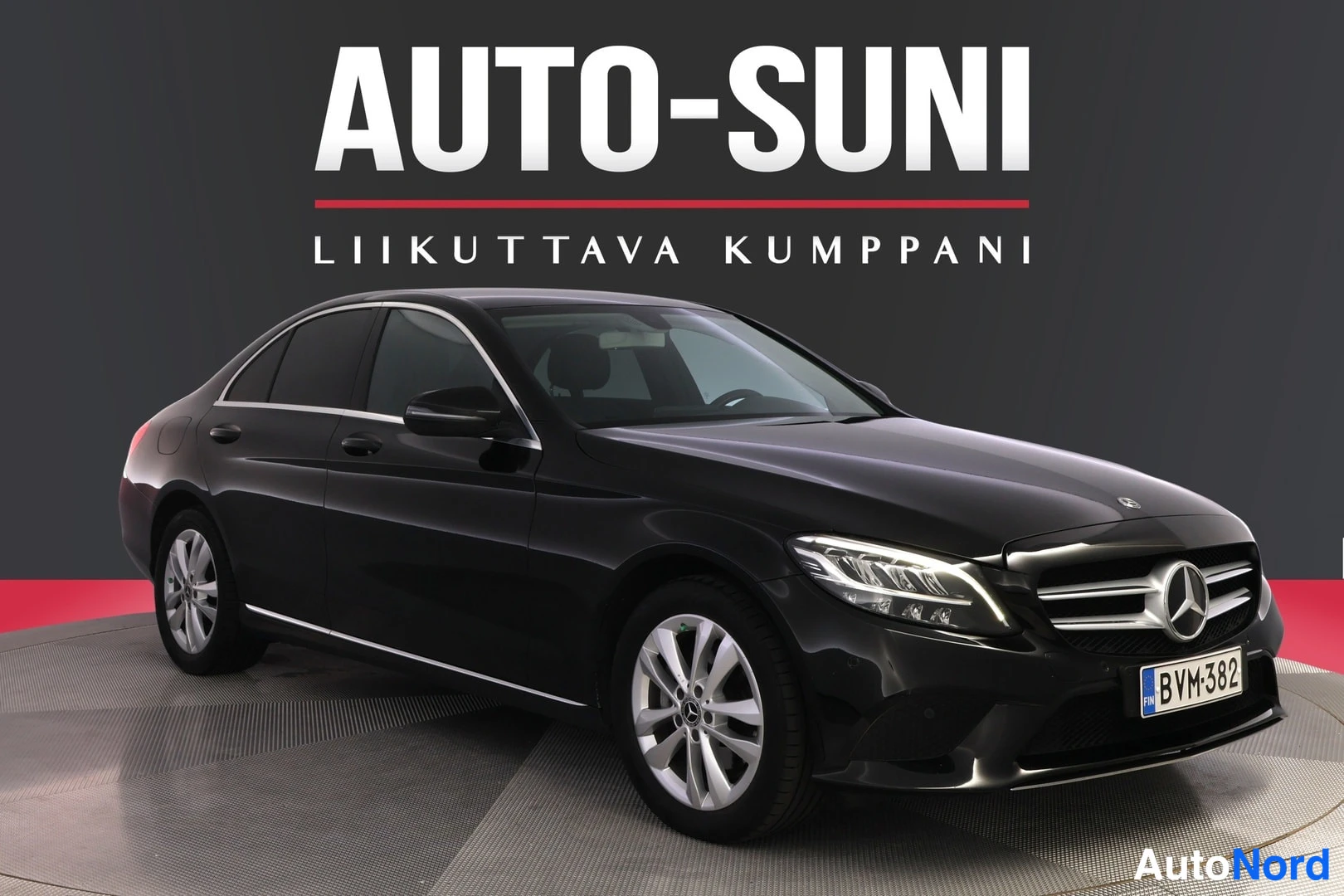 Etuviisto, nokka oikealle: Musta Mercedes-Benz-sedana esitellynä kiertuvassa alustassa. Kuvassa auto kolmella neljänneksellä etupuolelta, jossa näkyvät verhoilu ja oikea kylki.