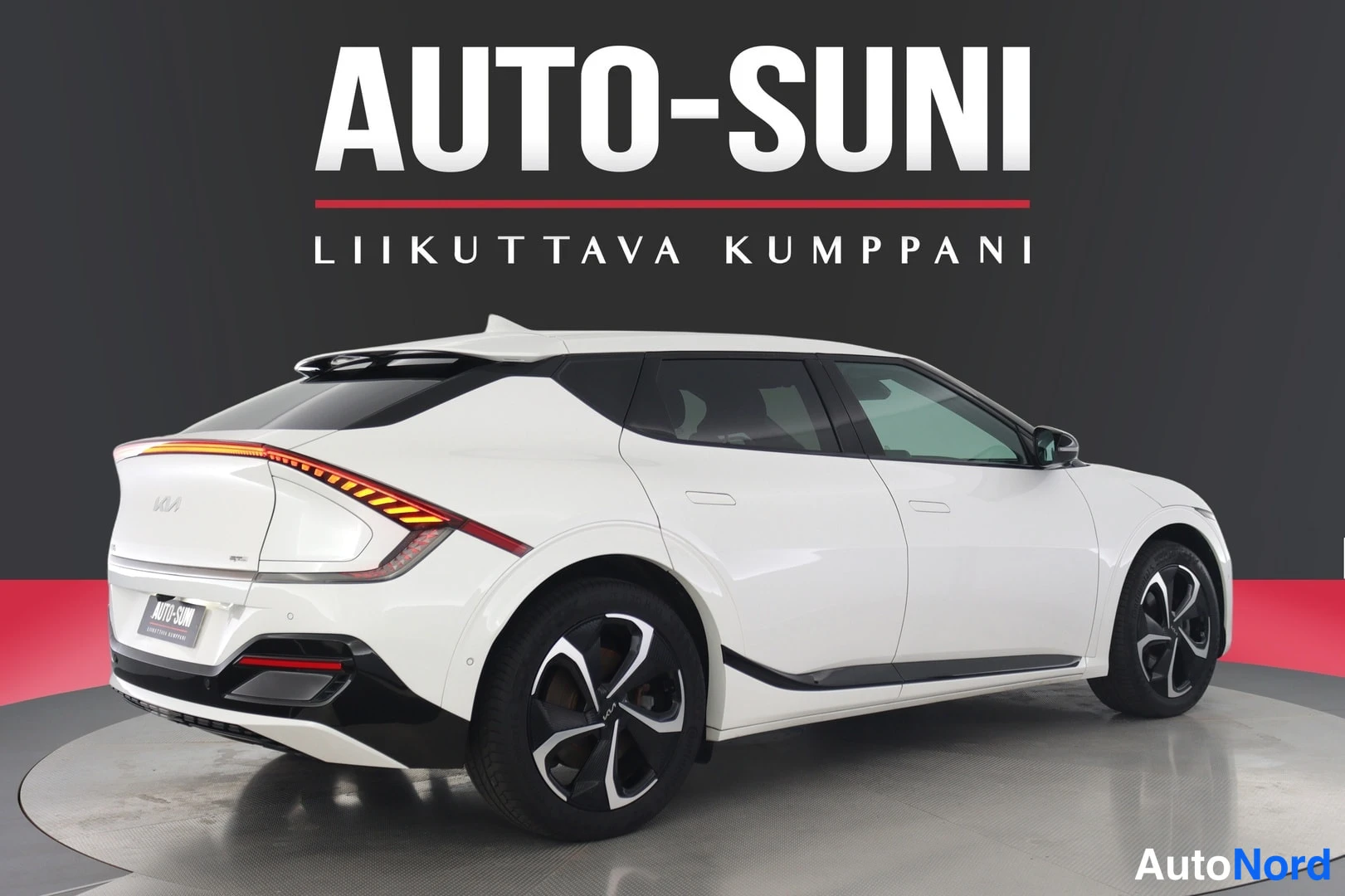 Takaviisto: Valkoinen Kia EV6 takakulmasta vasemmalta, virittynyt takavalo, musta takapuskurin alaosasto ja mustat kevytmetallivanteet.