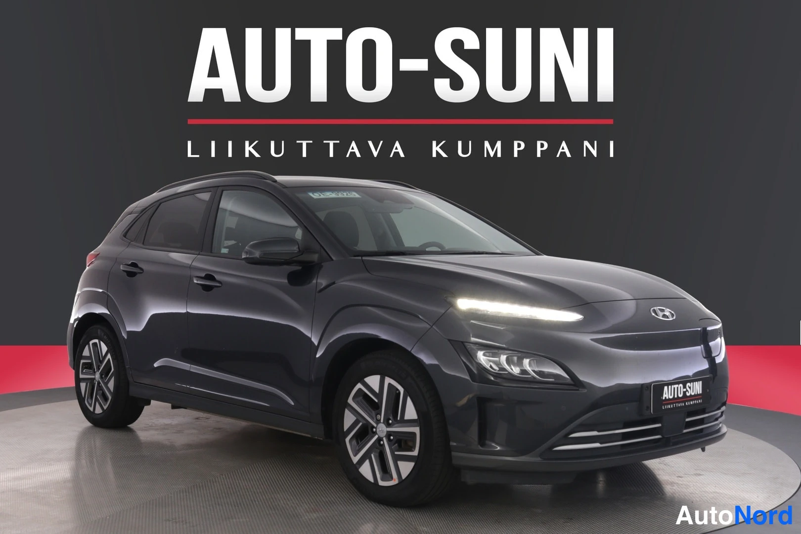 Etuviisto, nokka oikealle: Auton etukulma vasemmalta edessä, tummanharmaa kori, LED-päiväajovalot ja sentrimallin vanteet studiossa.