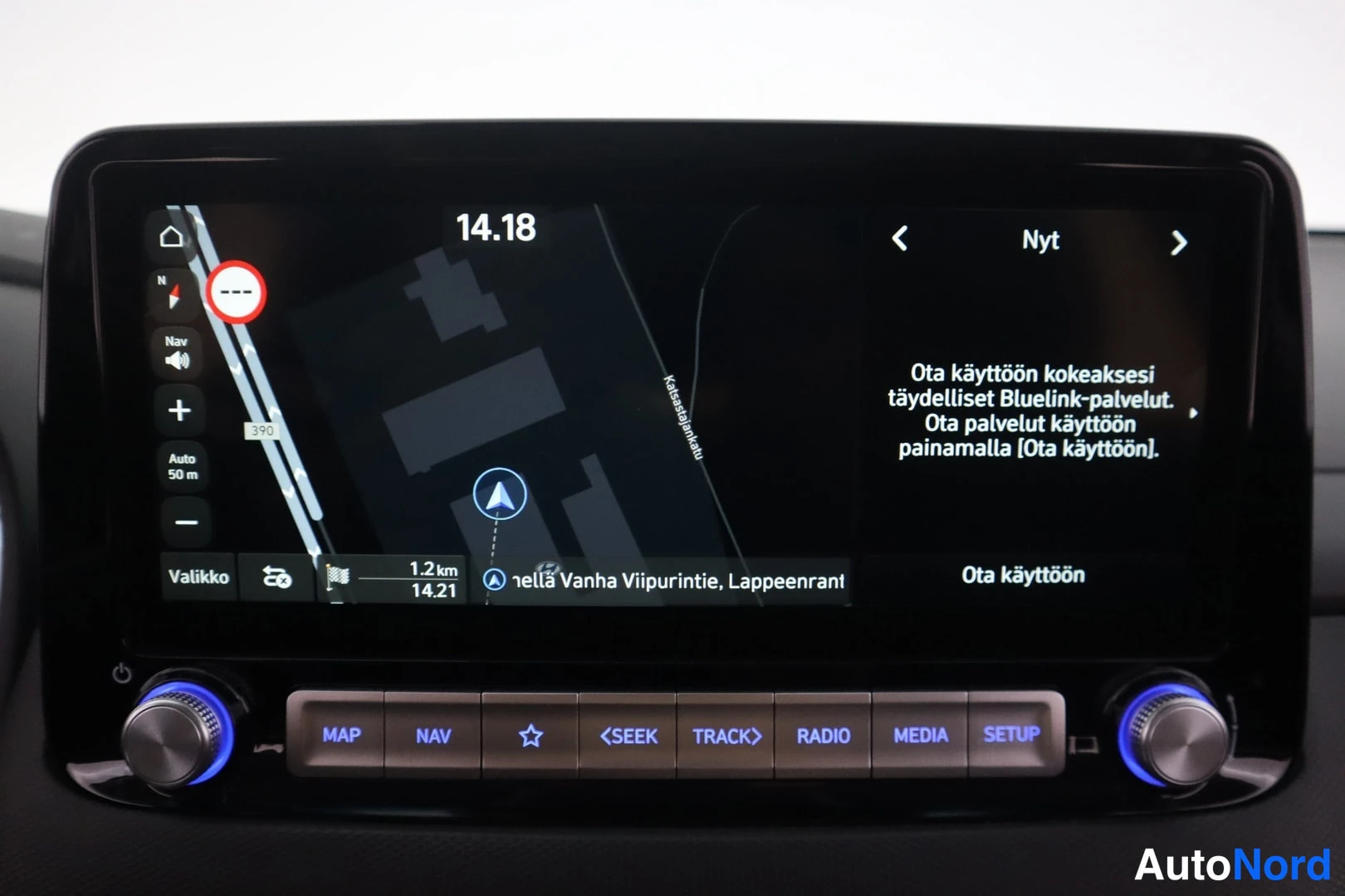 Muu: Auton infotainment-näyttö näyttää karttaa ja Bluelink-palveluiden aktivointikehotusta; alapuolella MAP-, NAV-, RADIO-, MEDIA- ja SETUP-napit sekä kaksi sinisest