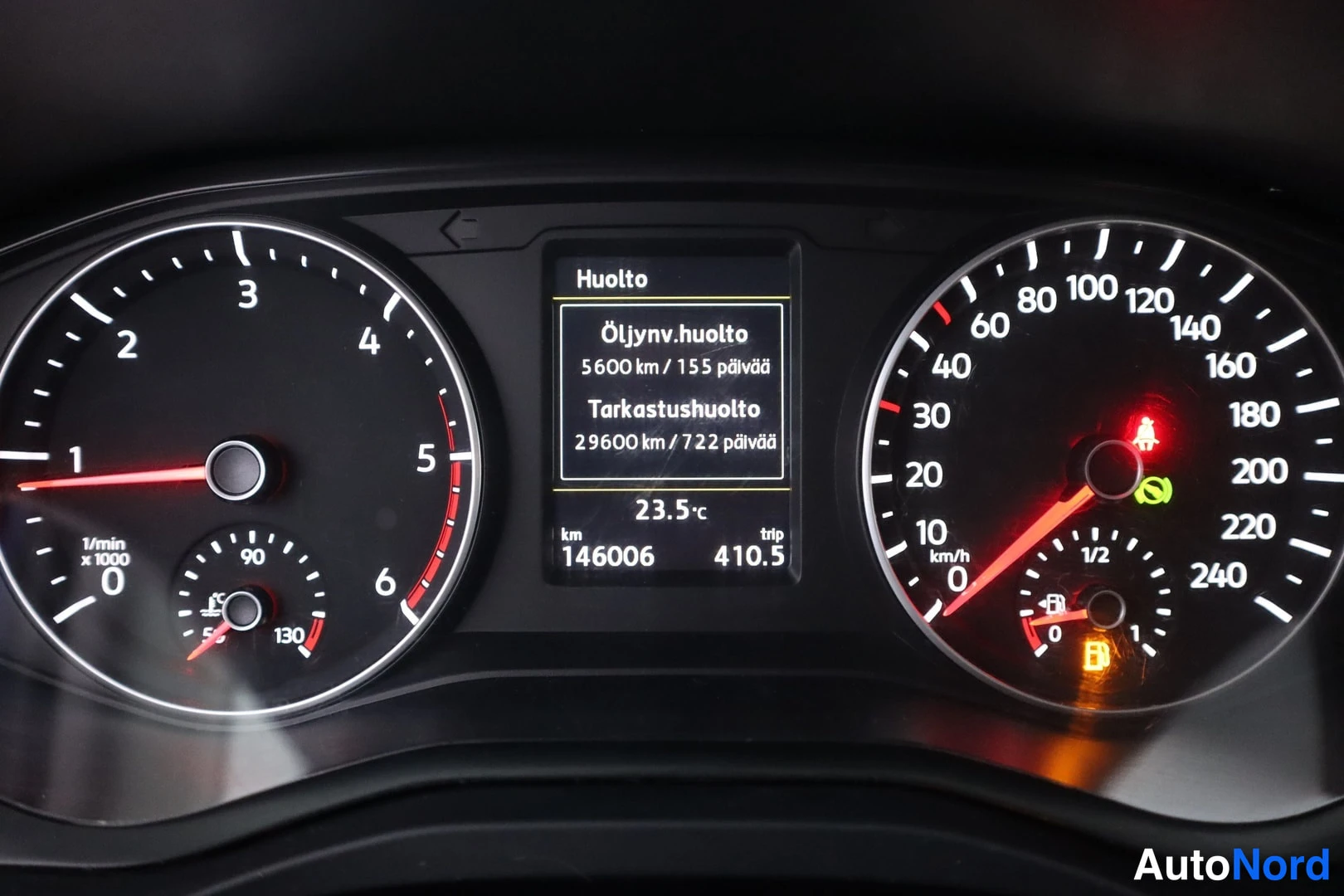 Yksityiskohta: Close-up view of a vehicle instrument cluster. A central digital display shows the heading 'Huolto' (Service) and maintenance details in Finnish: 'Öljynv.huolto