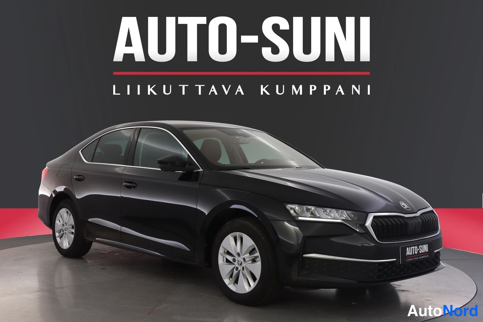 Etuviisto, nokka oikealle: Musta neliovinen henkilöauto etukulmakuvassa studiotaustalla, taustalla AUTO-SUNI-teksti.