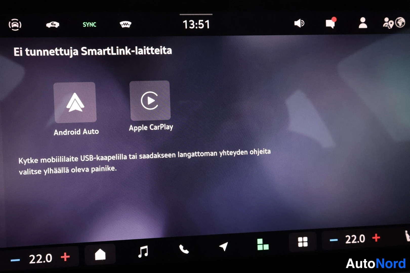 Yksityiskohta: Auton infotainment-näytön kuva. Näytössä on teksti 'Ei tunnettuja SmartLink-laitteita'. Näkyvillä ovat Android Auto ja Apple CarPlay -kuvakkeet sekä ohje teksti