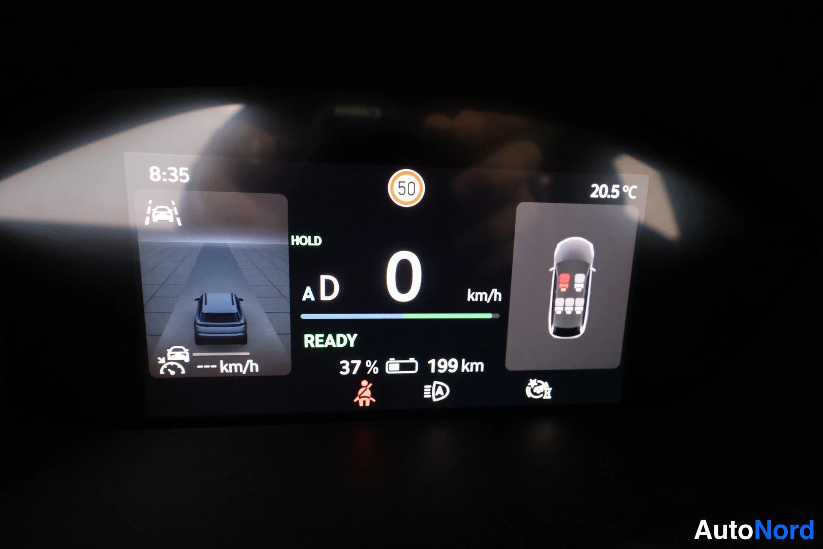 Yksityiskohta: Digitaalisella mittaristolla esitetään nopeusnäkymä sekä autojen tilanne. Näytöllä on ohjaustietoja: ajoajotila, nopeus (km/h), bensiinin määrä, kuluneisuus sek