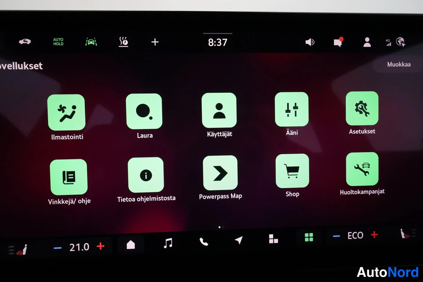 Yksityiskohta: Auton infotainment-näytön Sovellukset-valikko suomeksi: Ilmastointi, Laura, Käyttäjät, Ääni, Asetukset, Vinkkejä/ohje, Tietoa ohjelmistosta, Powerpass Map, Shop